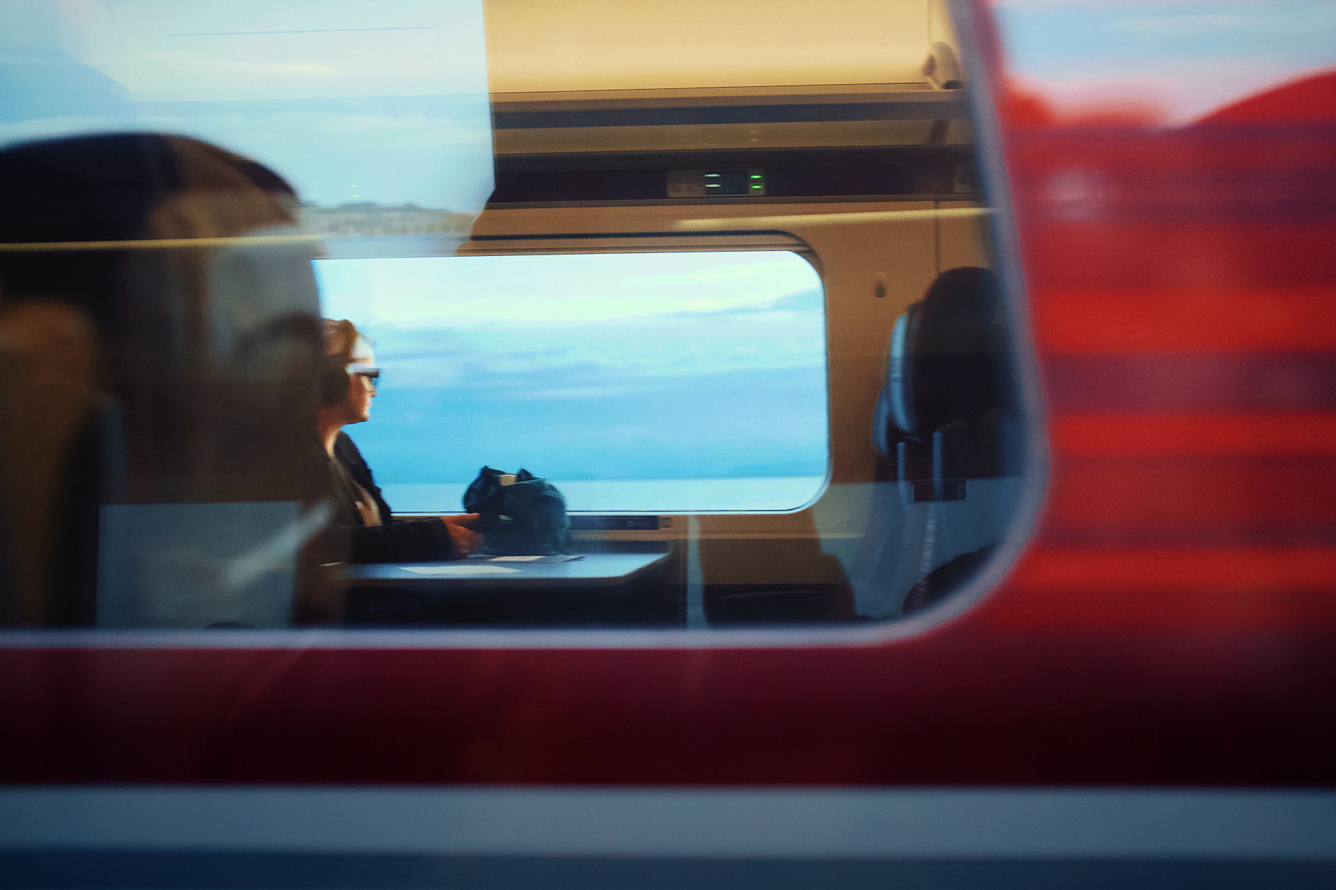 Person gazing at the scenic view from a moving train.
