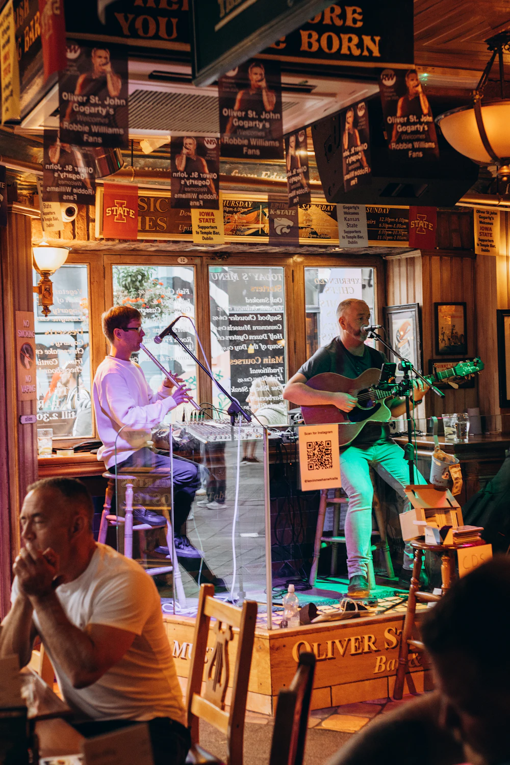 Two musicians playing live music in a cosy pub