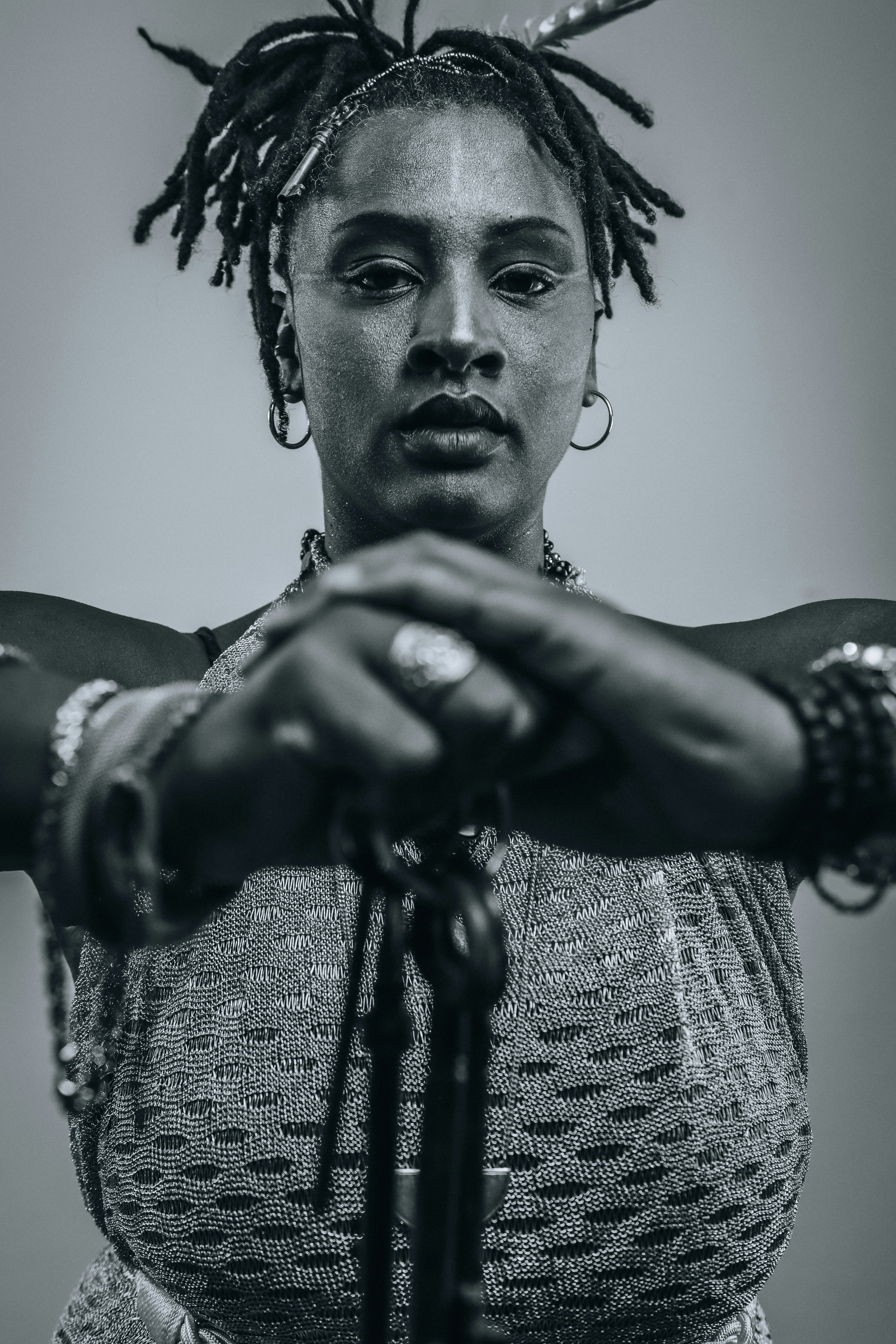 Woman with dreadlocks, jewelry, and tassels looking forward.