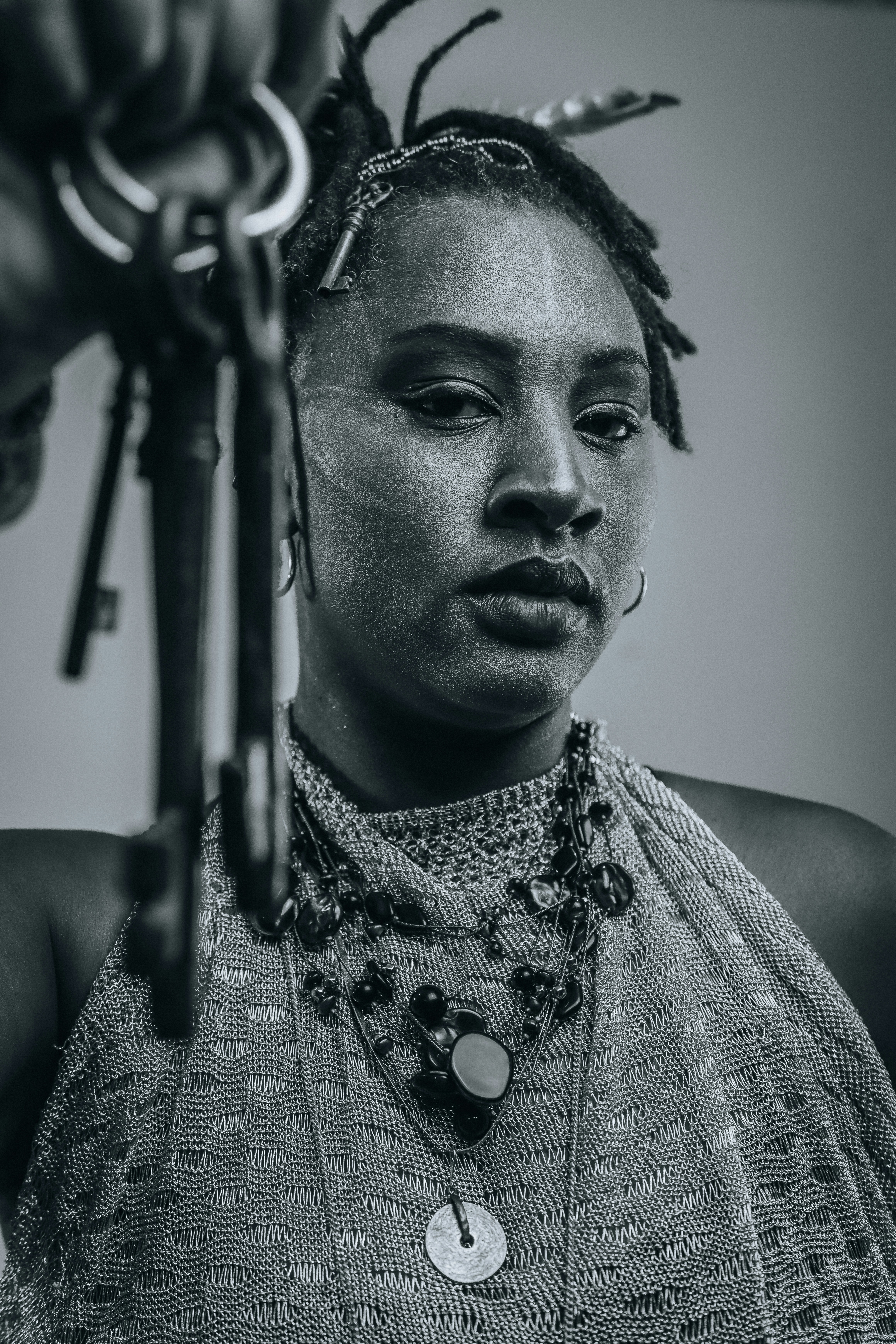 Person with dreadlocks holds antique keys.