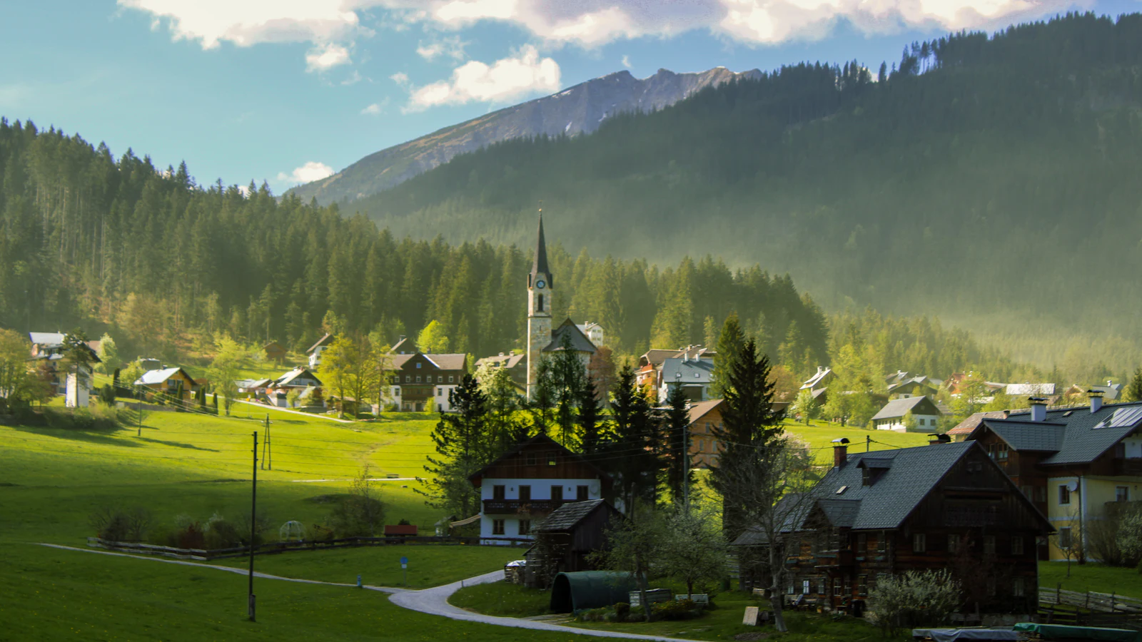 Village de montagne au clocher, au fond d'une vallée alpine (photo d'illustration)