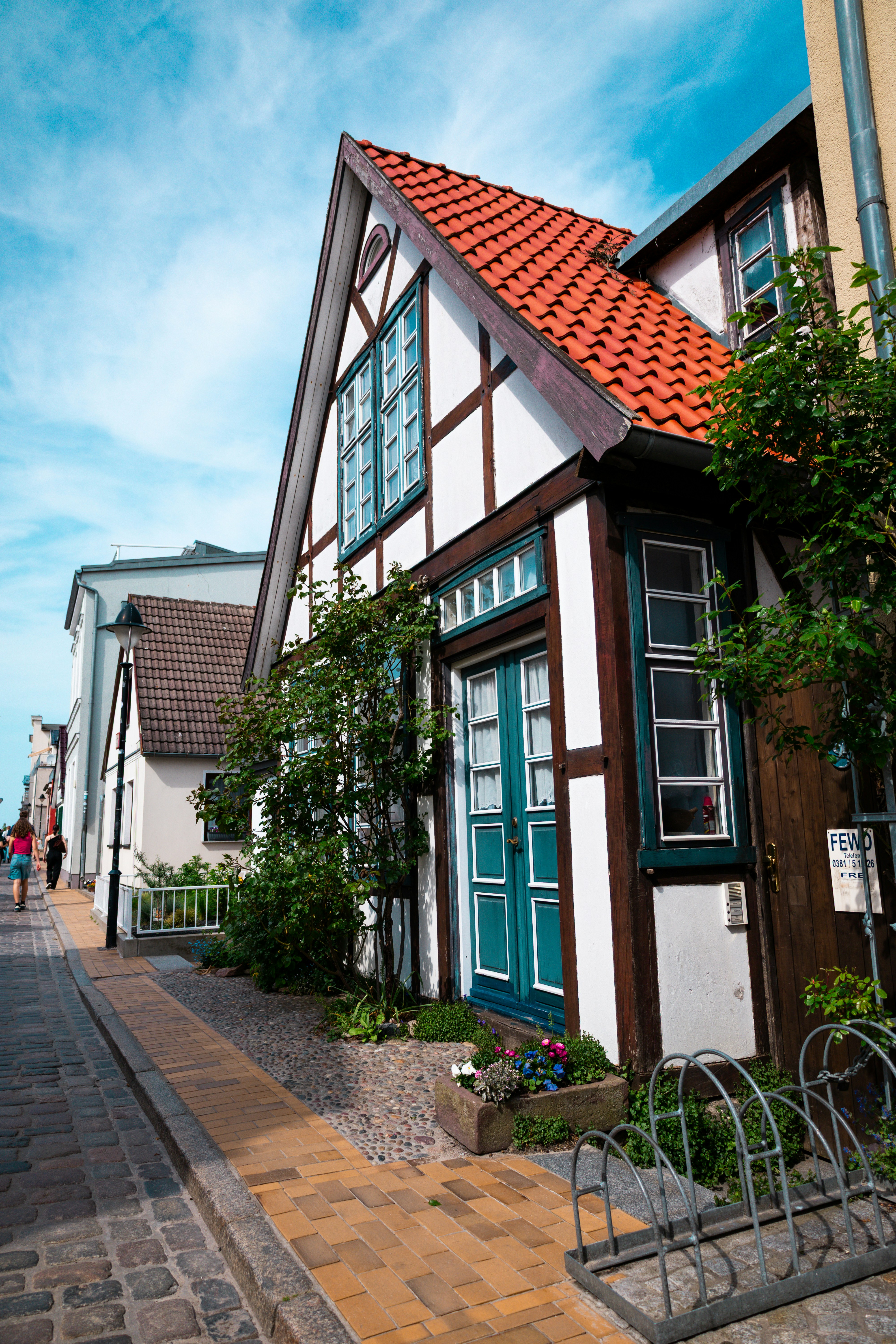 Charming half-timbered house with red roof and blue door.