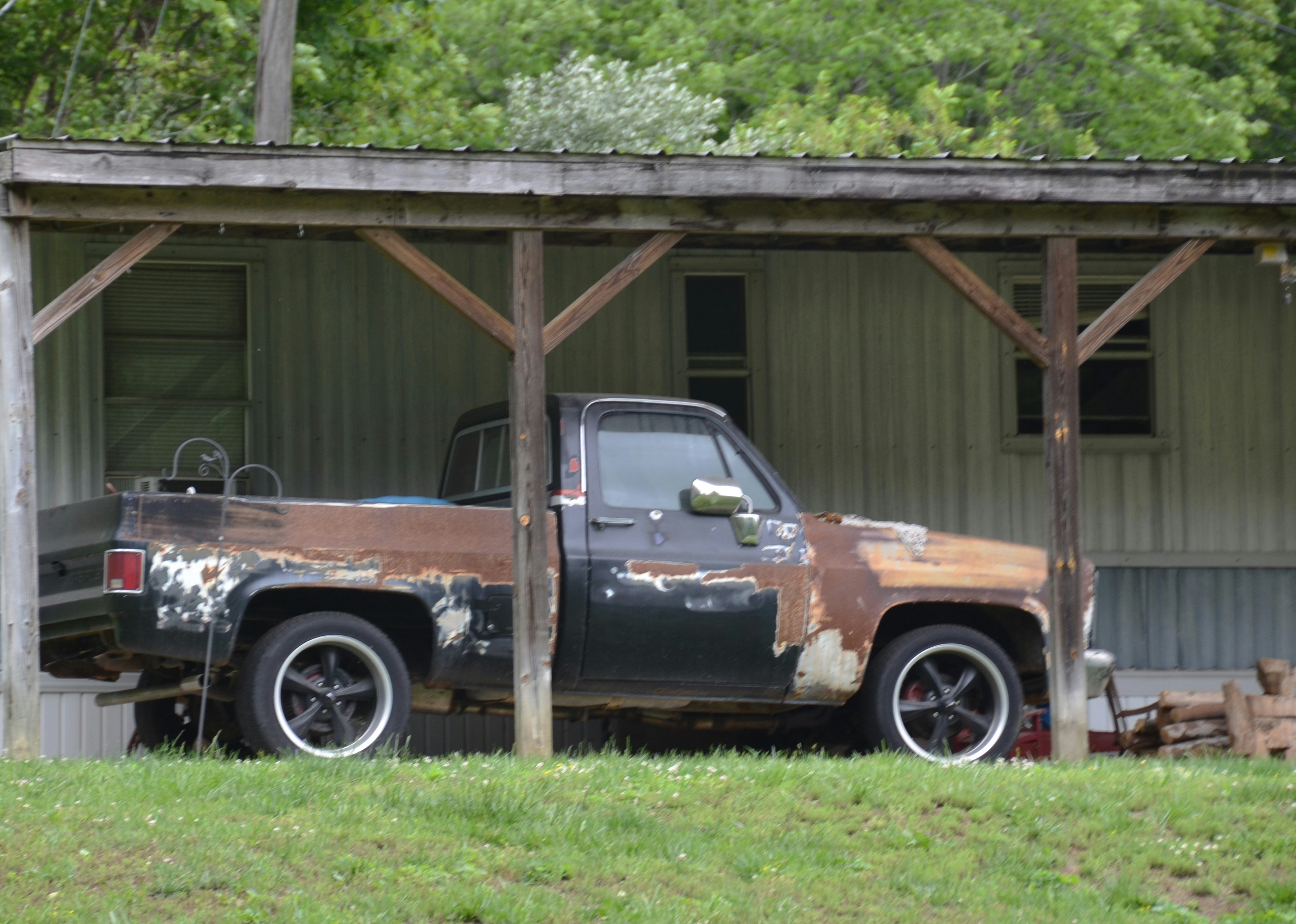 A weathered pickup truck bed showing rust and oxidation from exposure to the elements.