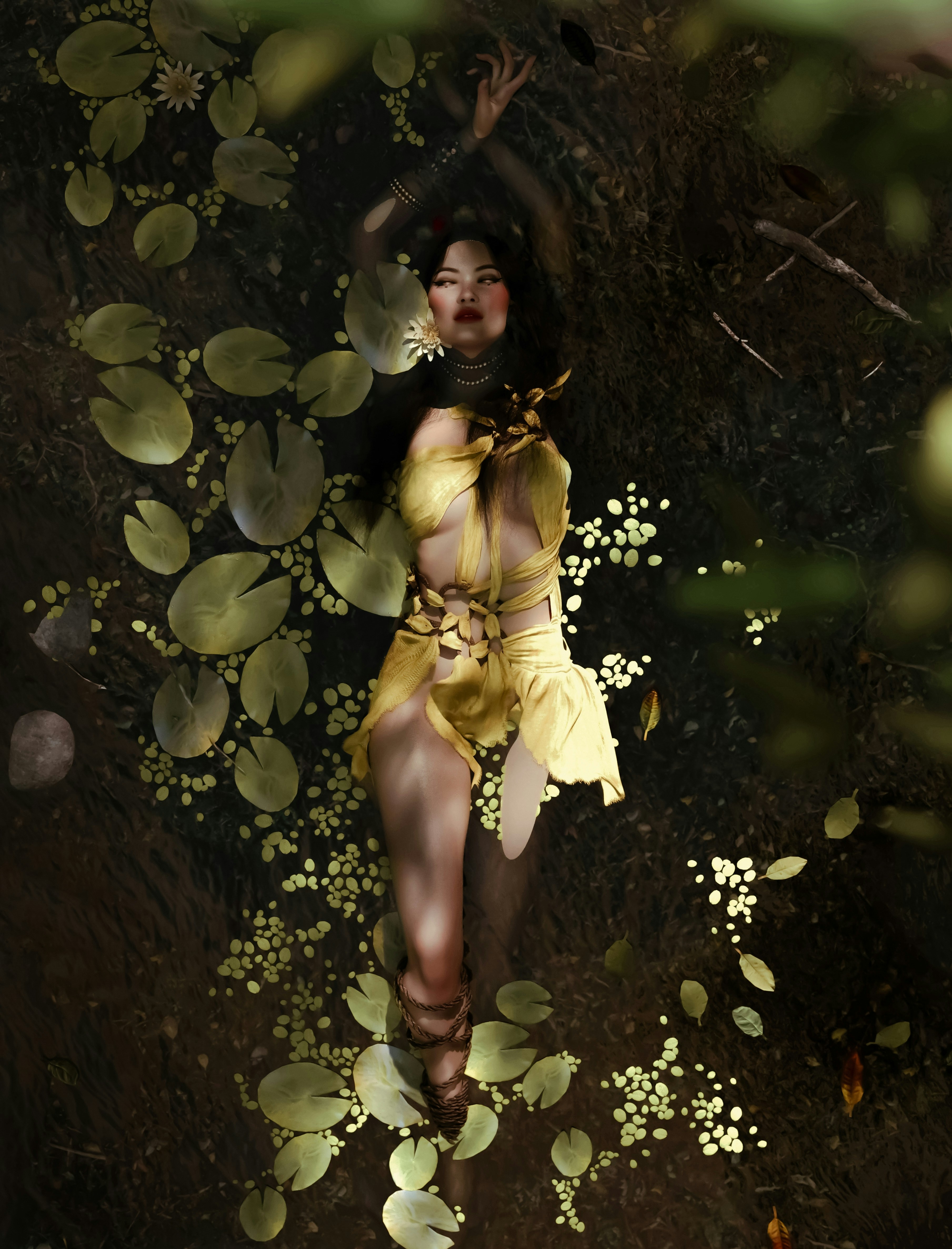 Woman in yellow dress lying in water with lily pads