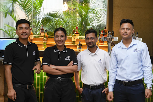 Four smiling restaurant staff members