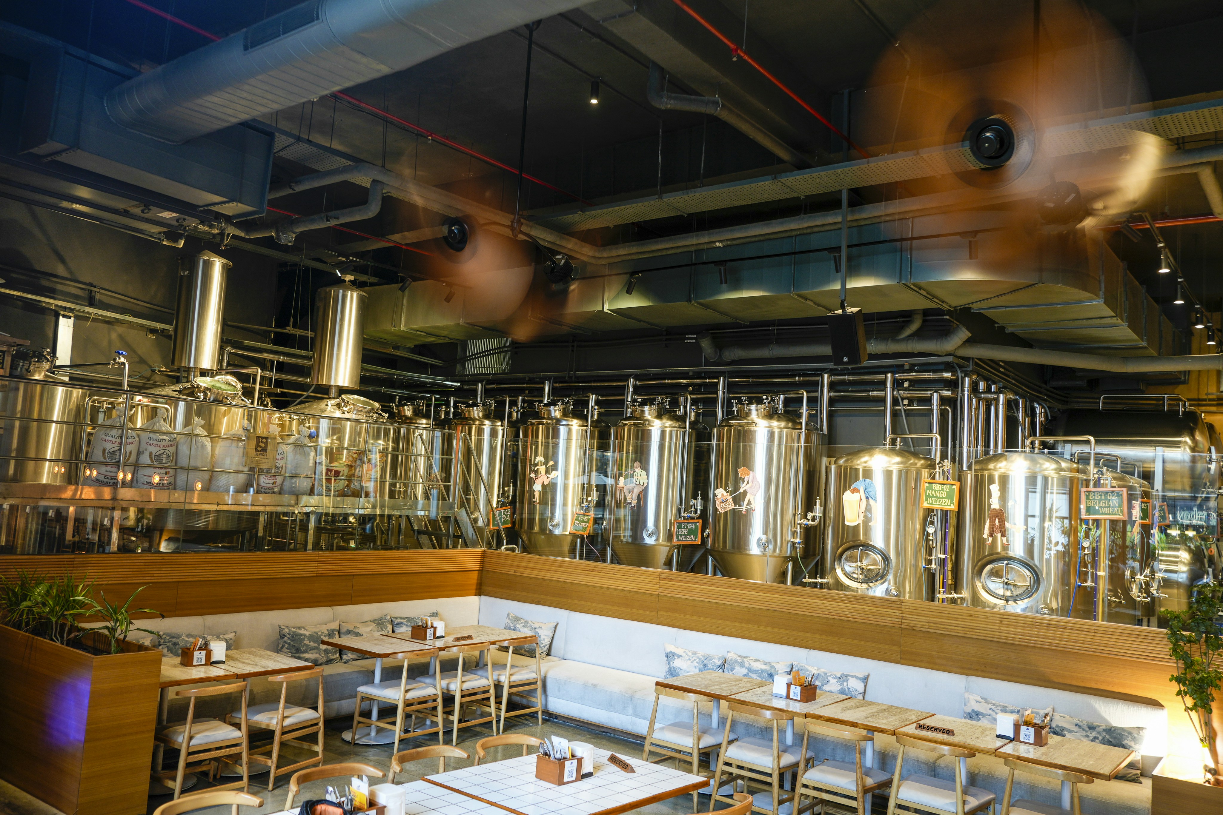 Salle de restaurant de brasserie artisanale avec cuves en arrière-plan