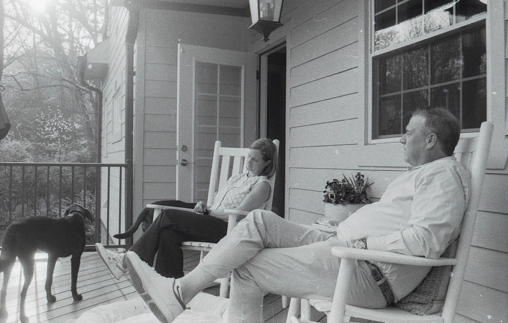 A couple and their dog relaxing together on their porch