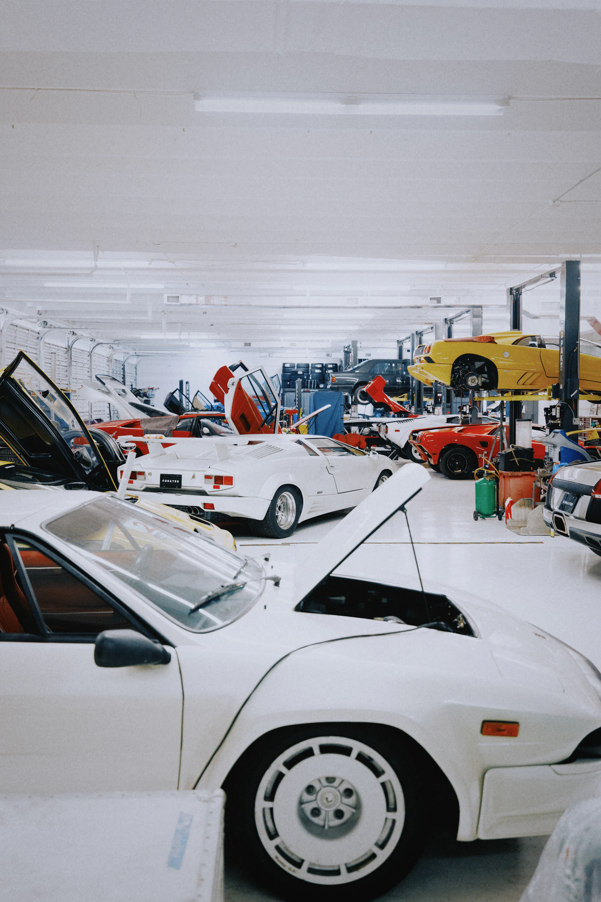 Atelier auto cu podea alba epoxidica si masini premium in spatiu curat