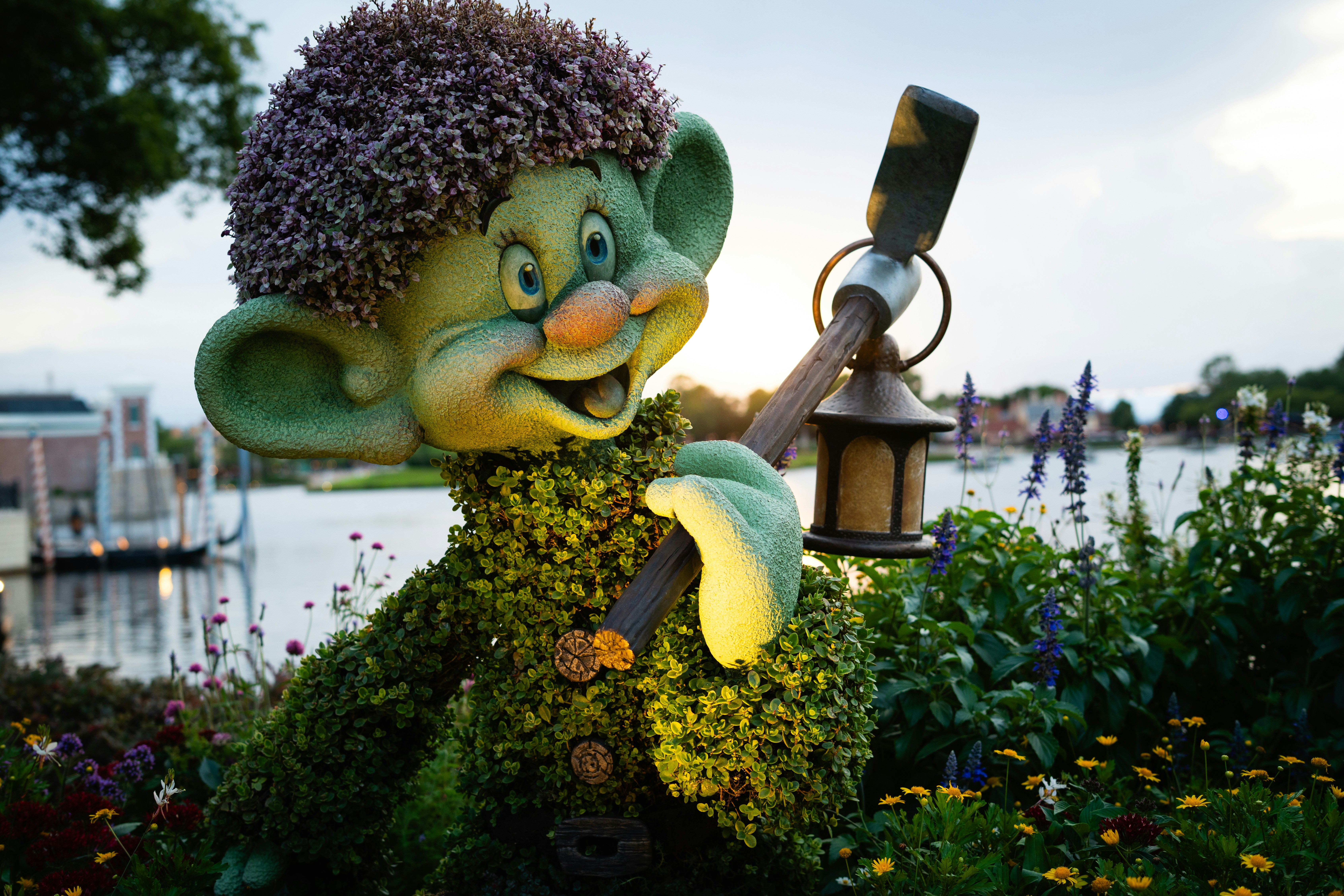 Sosok topiary dopey memegang lentera saat matahari terbenam.