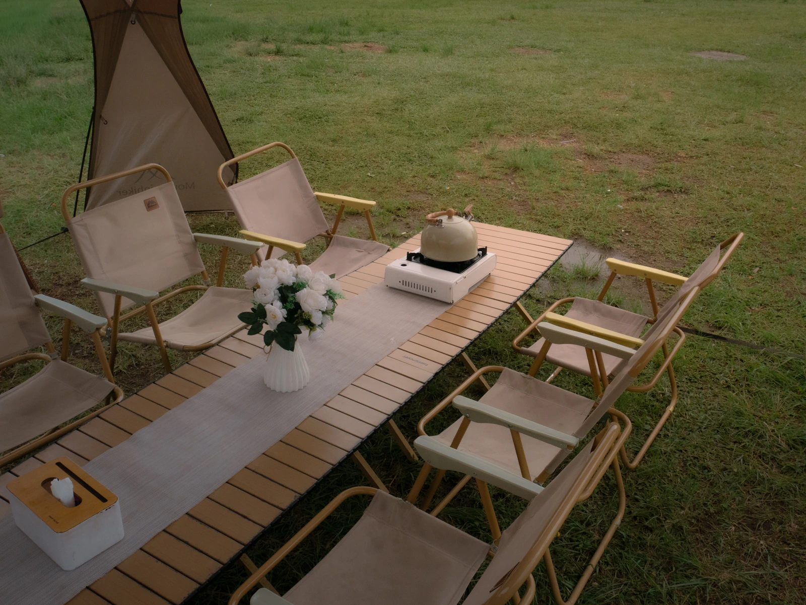 Outdoor camping table and chairs arranged on grass