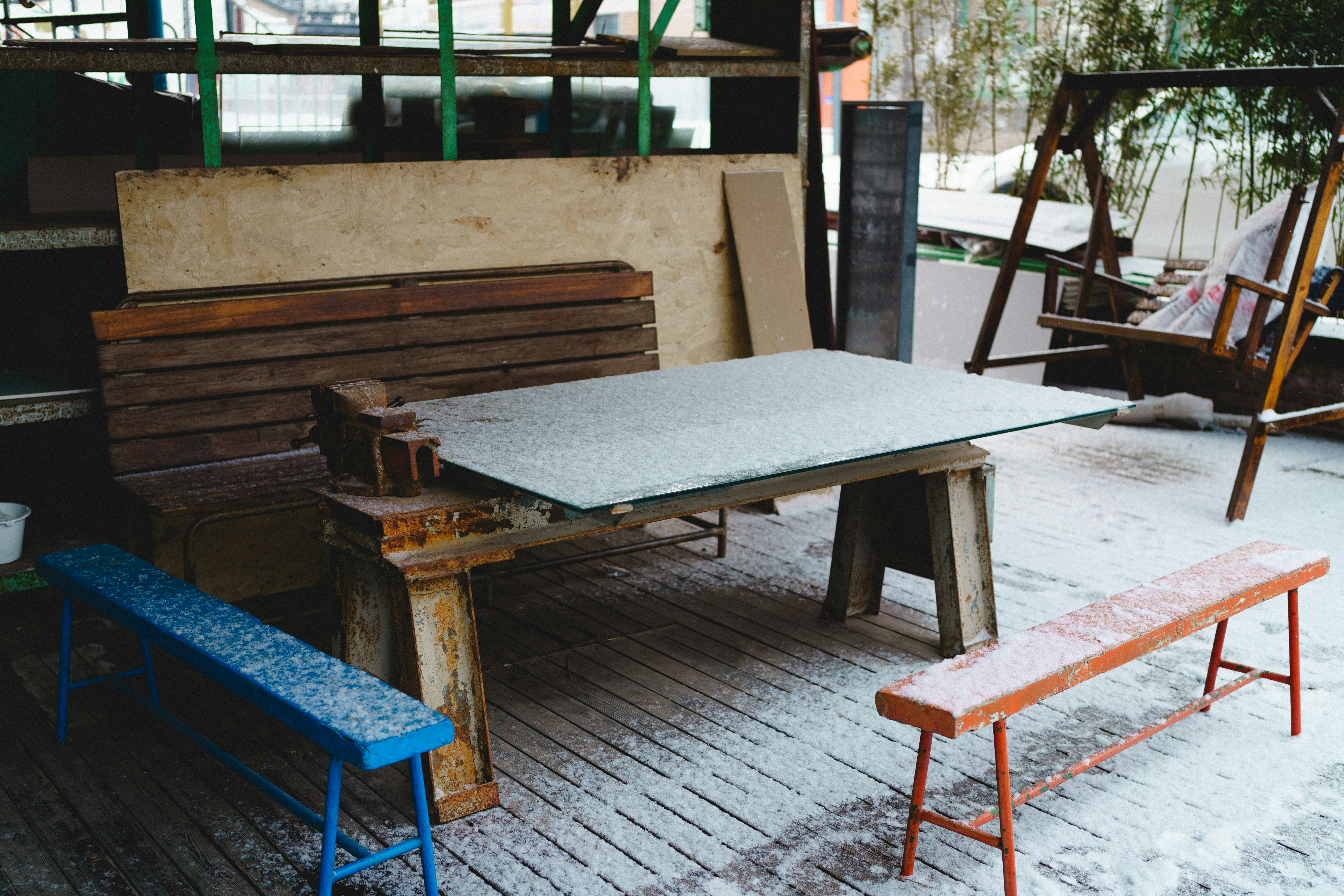 "Zone extérieure enneigée avec table, bancs et balançoire en matériaux durables pour mobilier extérieur"