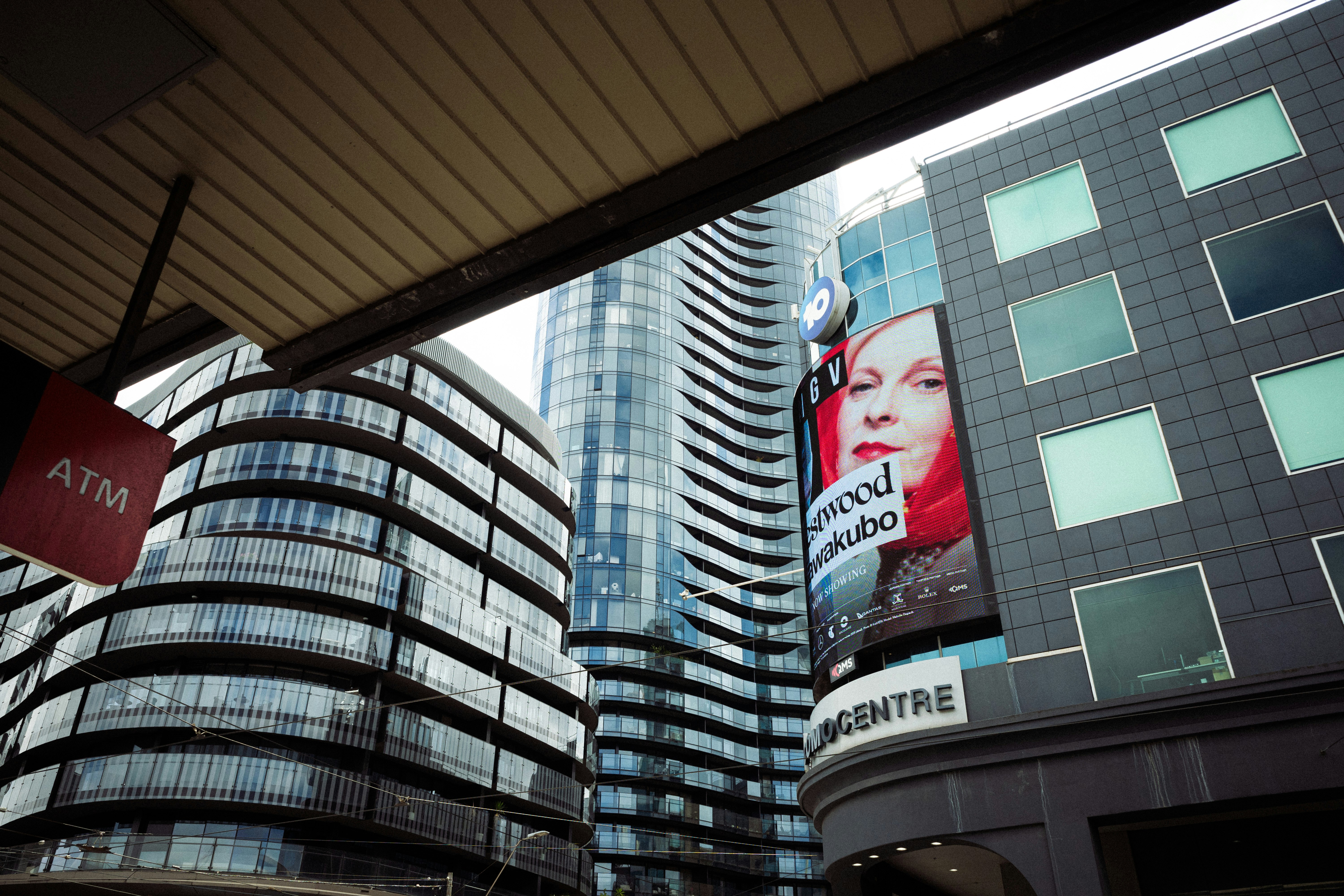 City skyline featuring modern buildings and a prominent billboard.