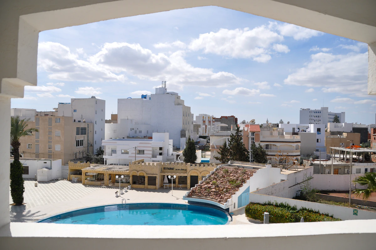 A hotel swimming pool with white buildings behind