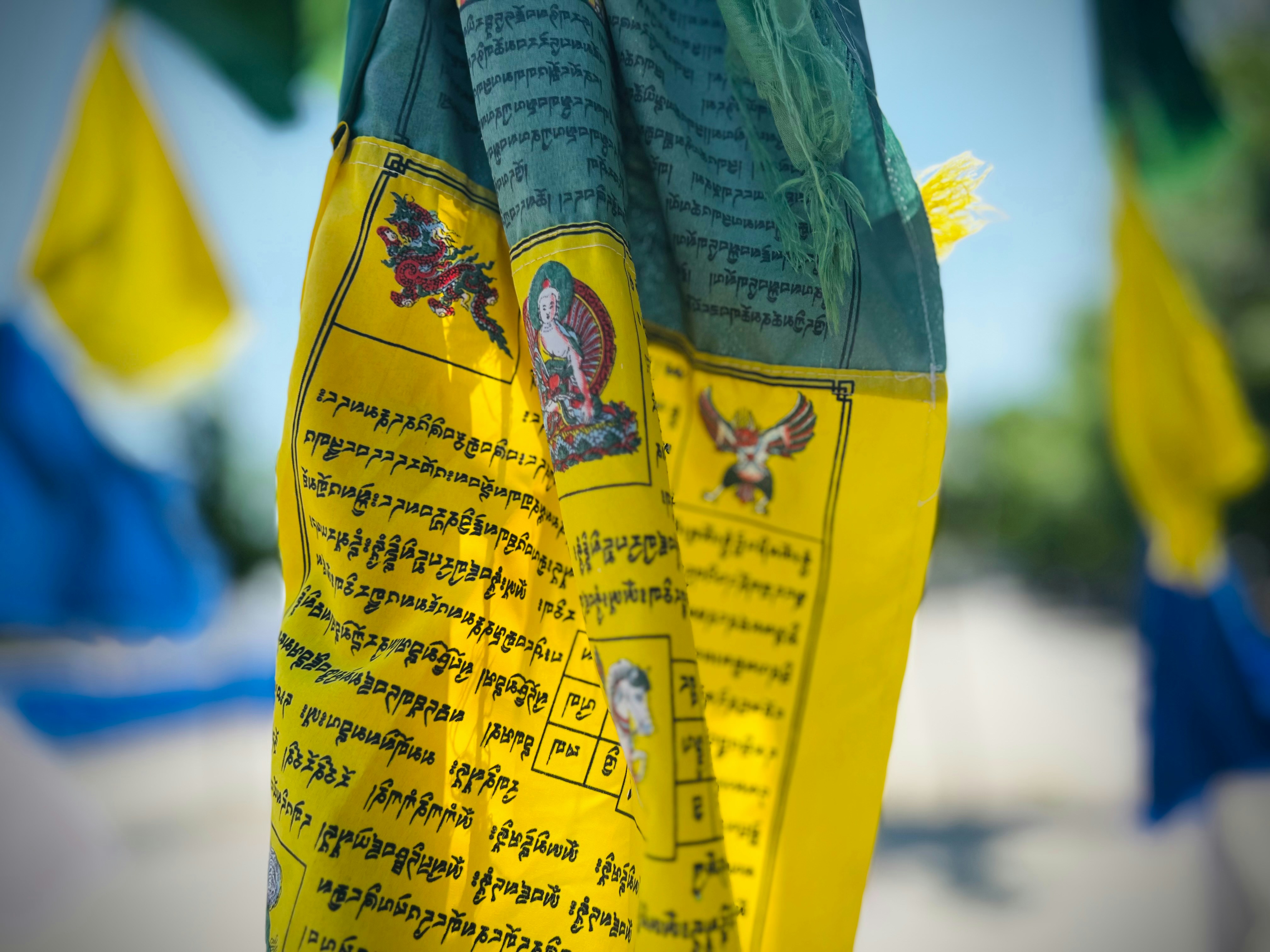 Una bandiera tibetana gialla con scritte e simboli.
