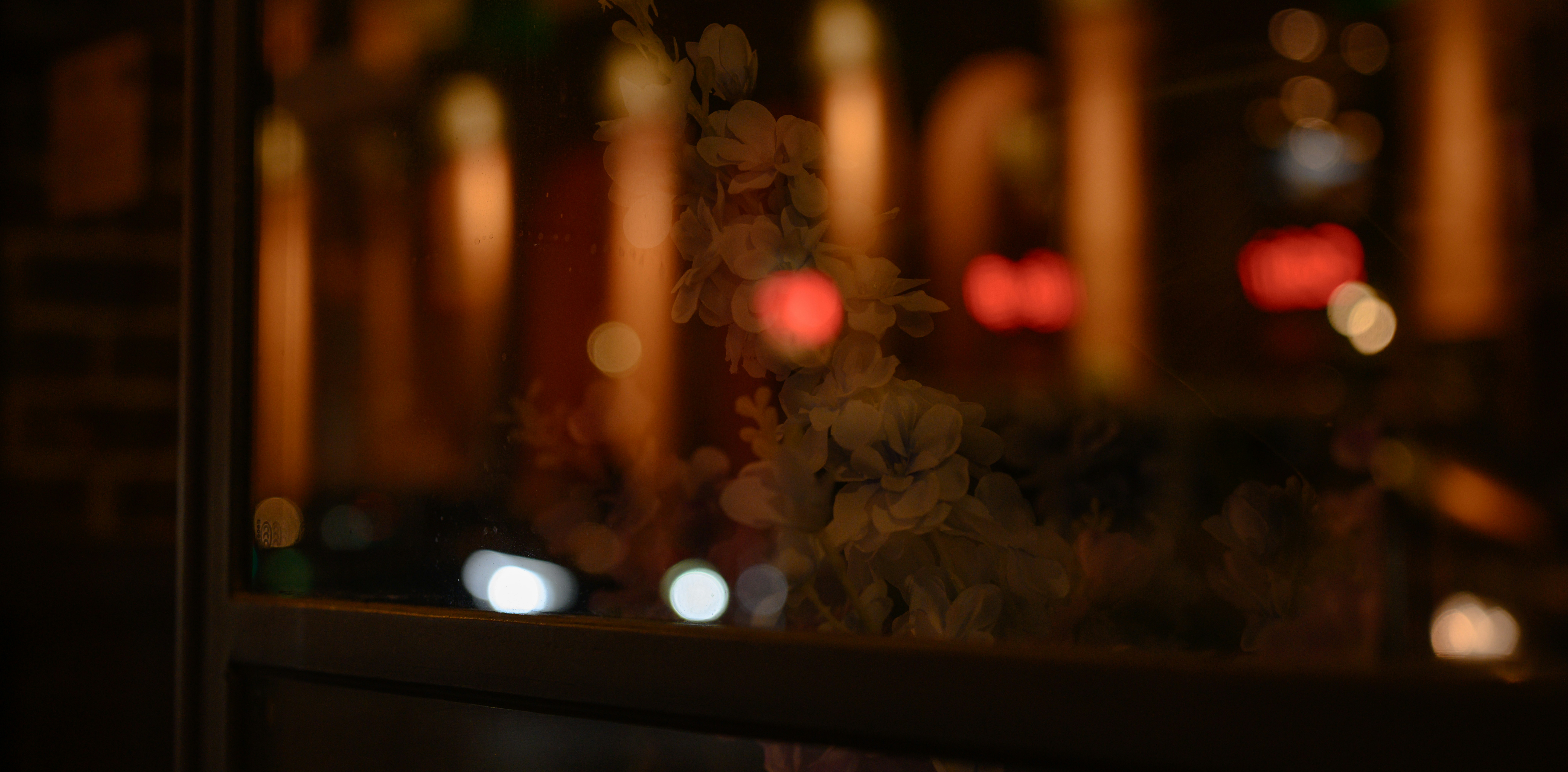 Blurred city lights reflecting in a window at night.