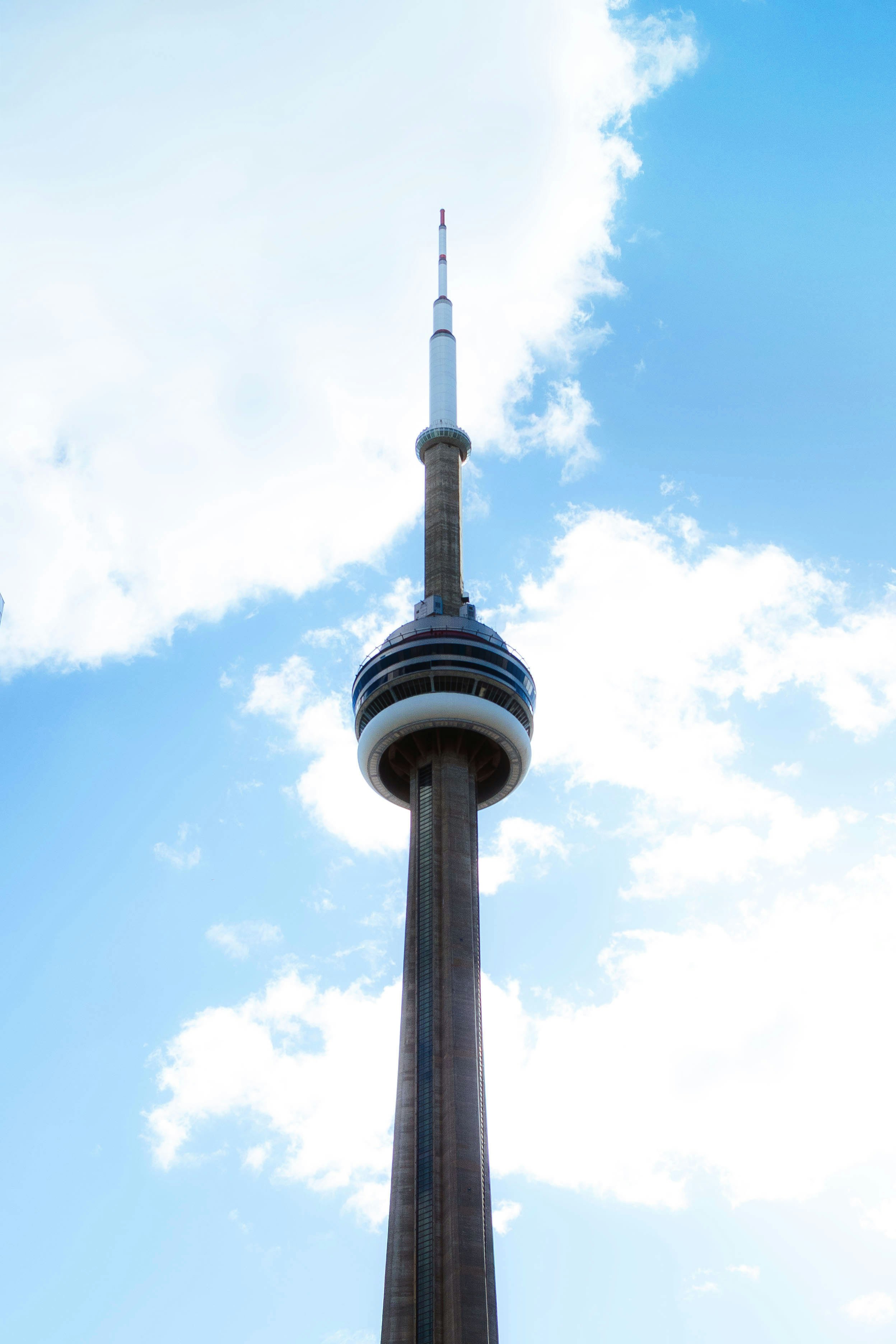 The cn tower stands tall against a blue sky.