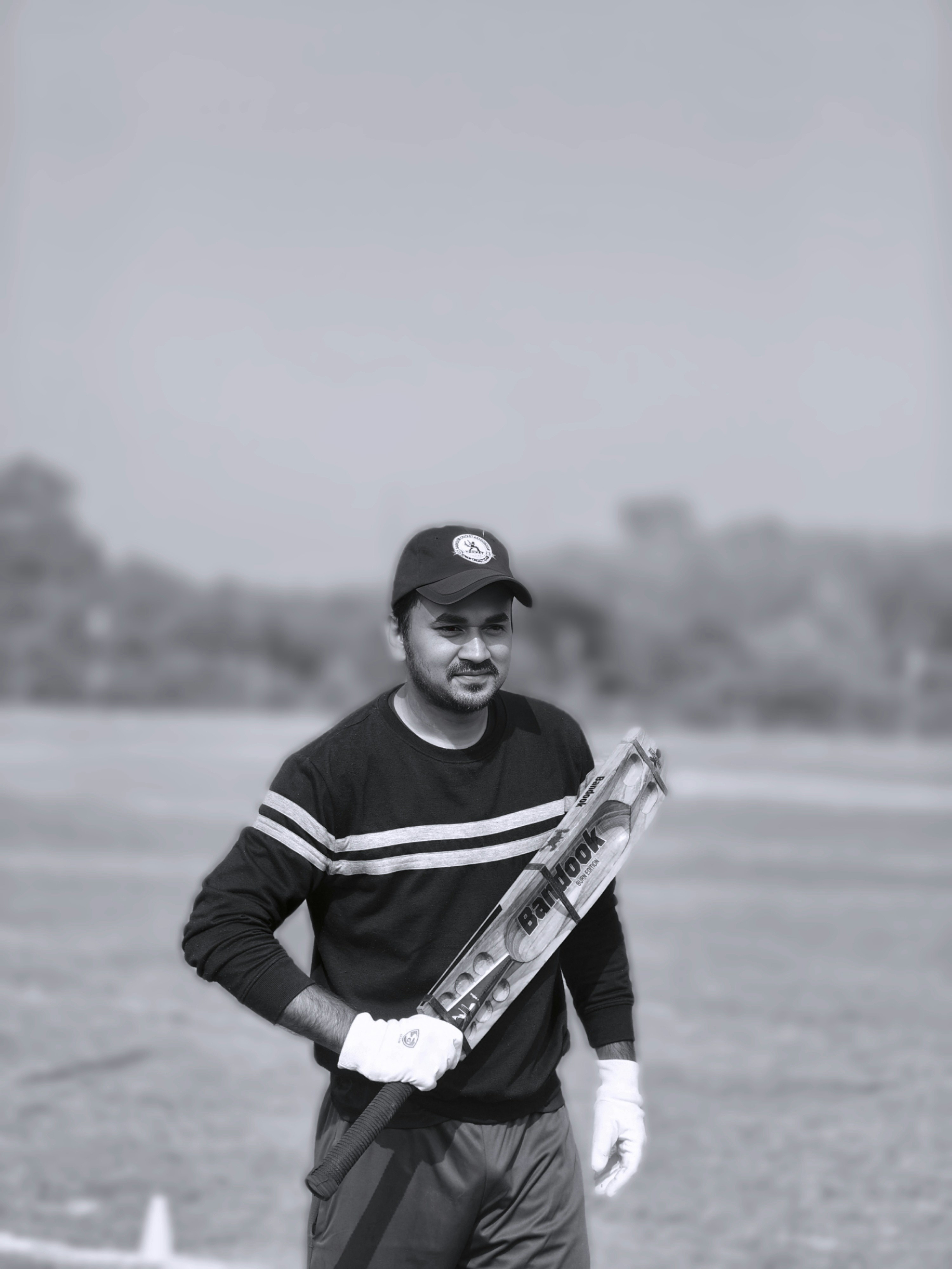 Un uomo che tiene una mazza da cricket su un campo.