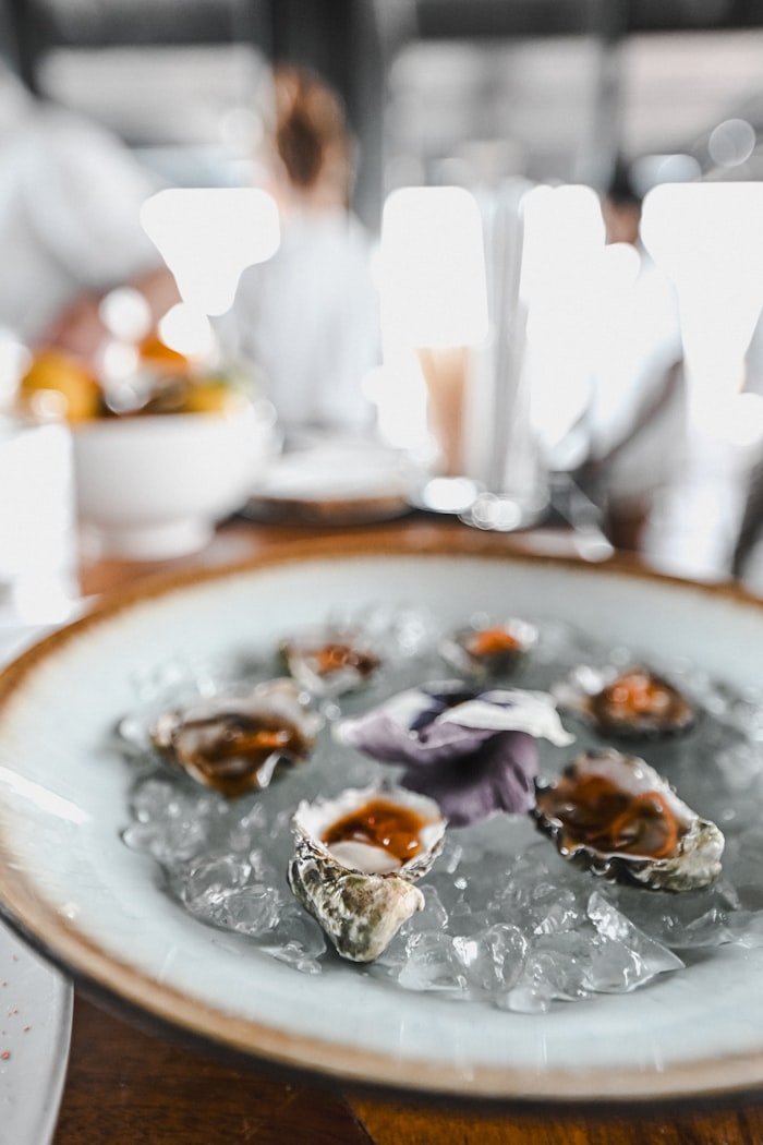 Douzaine d'huîtres fraîches sur glace, garniture fleurie — service restaurant
