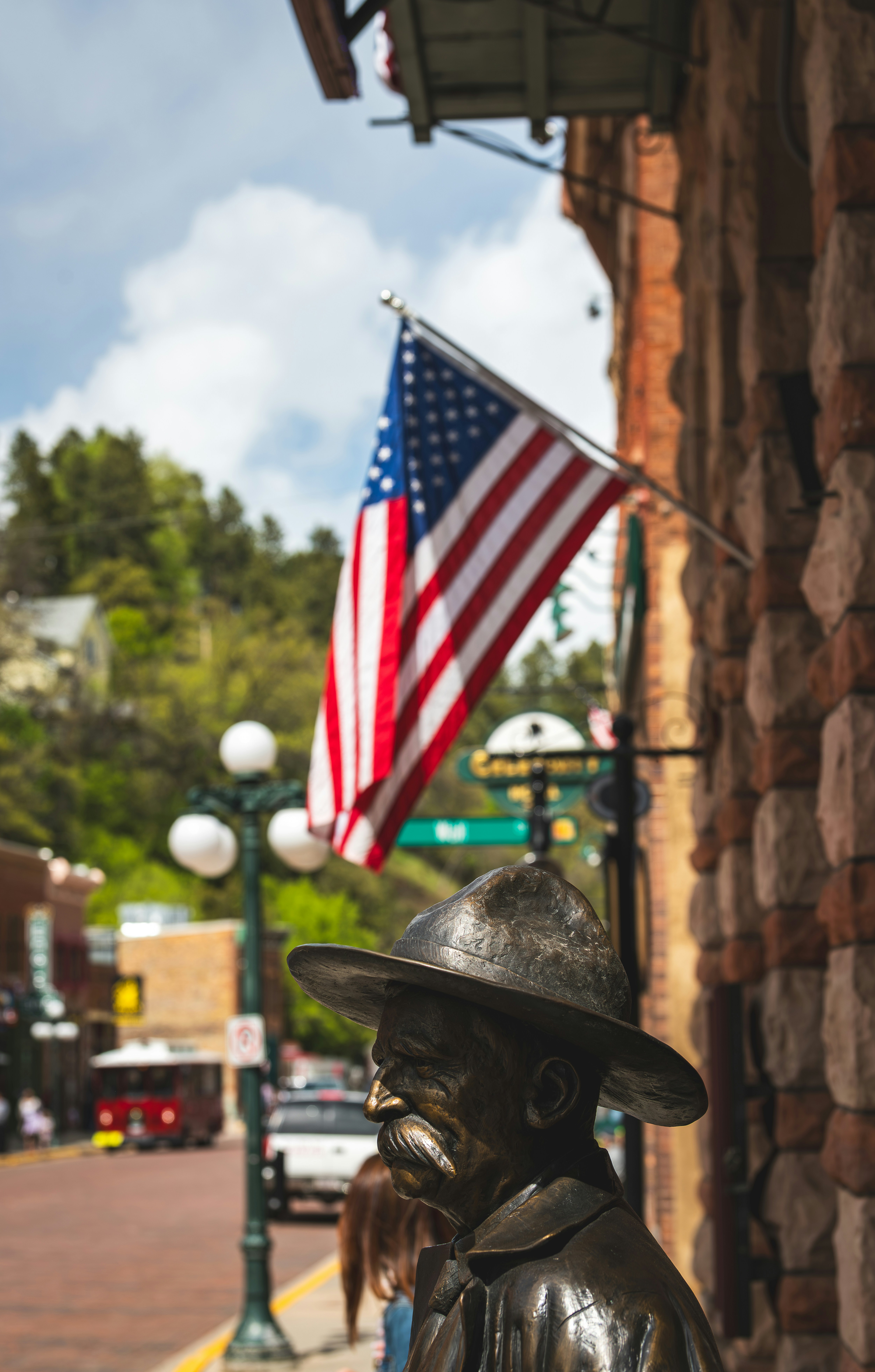 Uma estátua de bronze de um homem com uma bandeira americana.