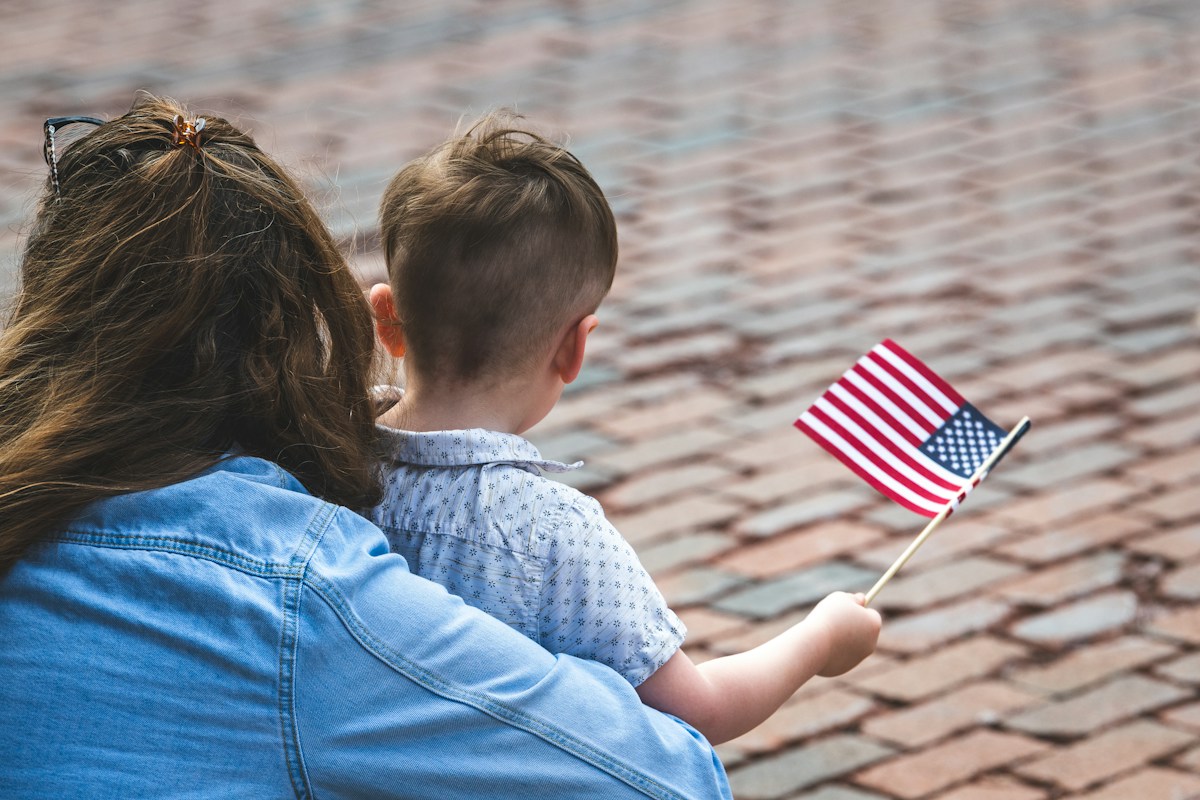 Mother and child holding a small American flag