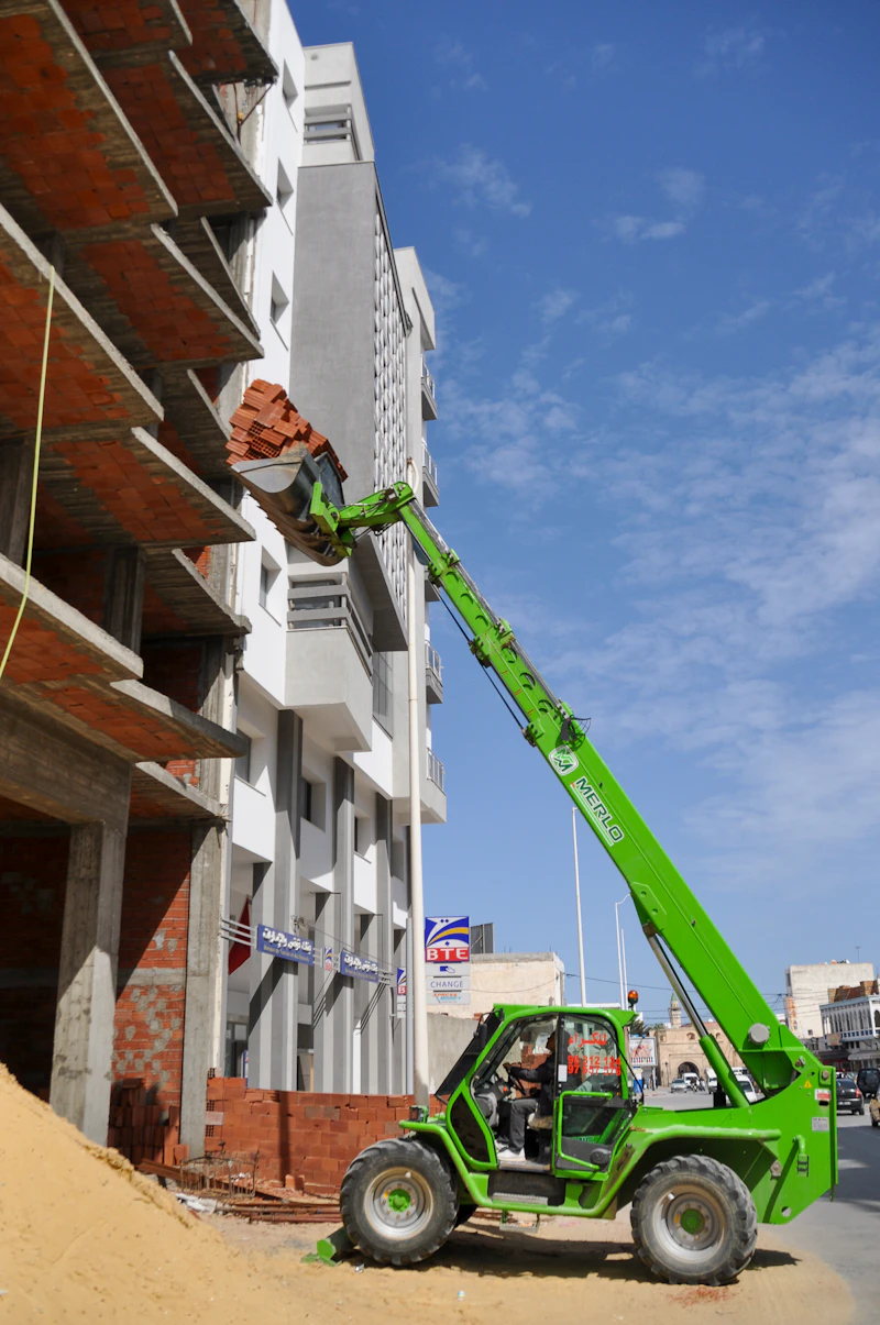 Telehandler lifting bricks at construction site