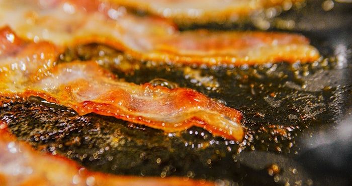 Crispy bacon frying in a pan