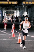 A man runs a marathon race through an underpass.