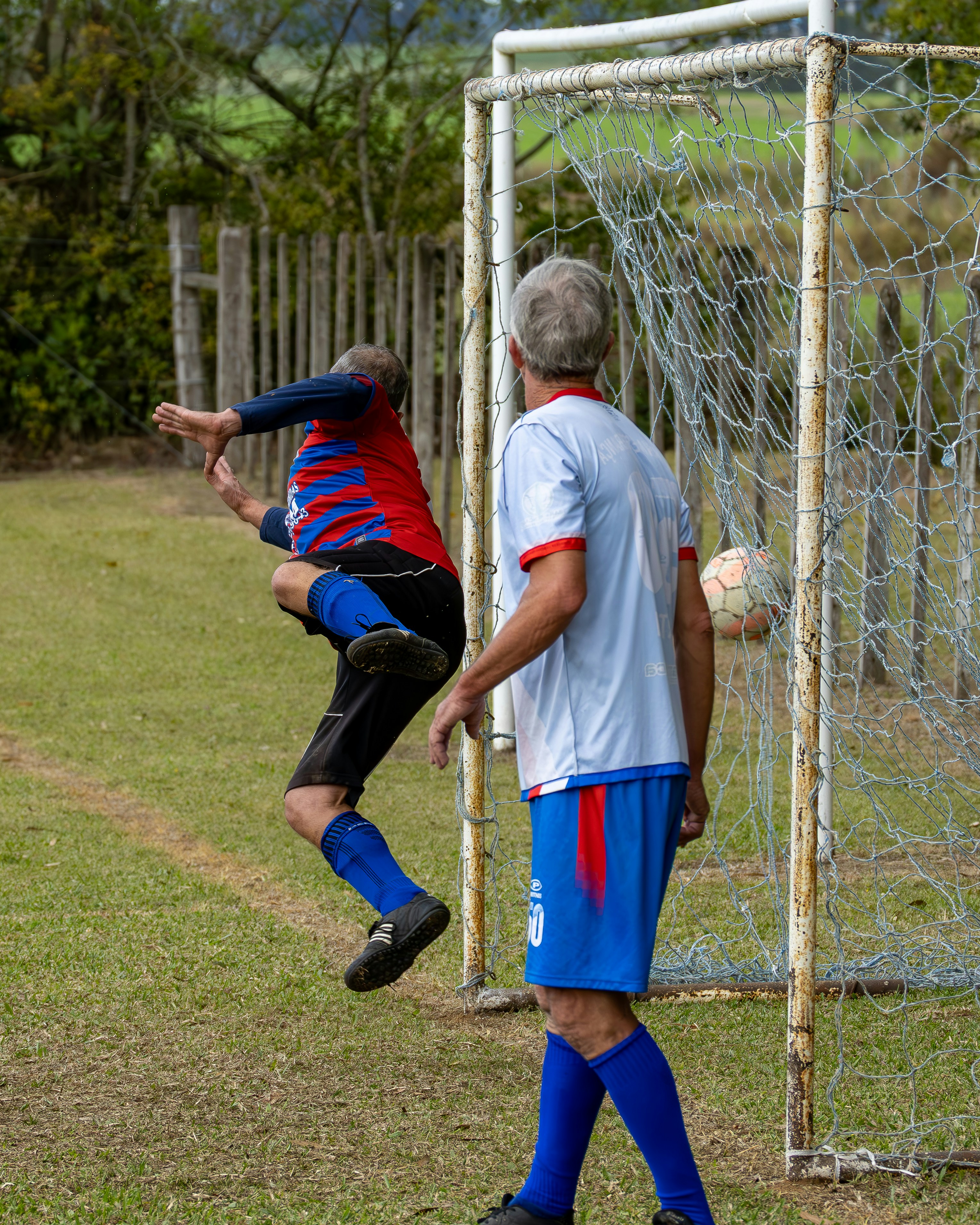 Player jumps to kick soccer ball into goal