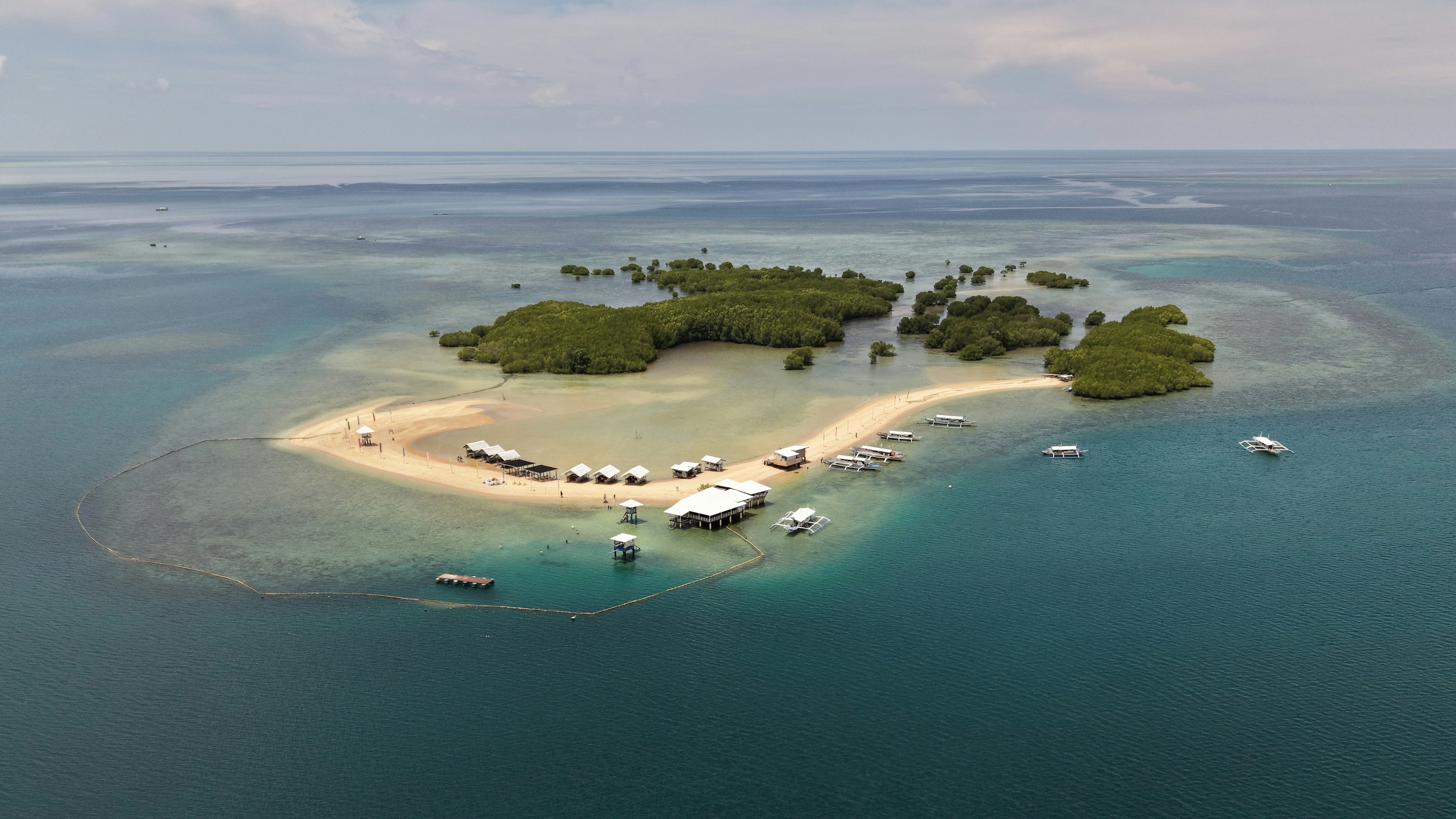 Aerial view of a small tropical island with boats.