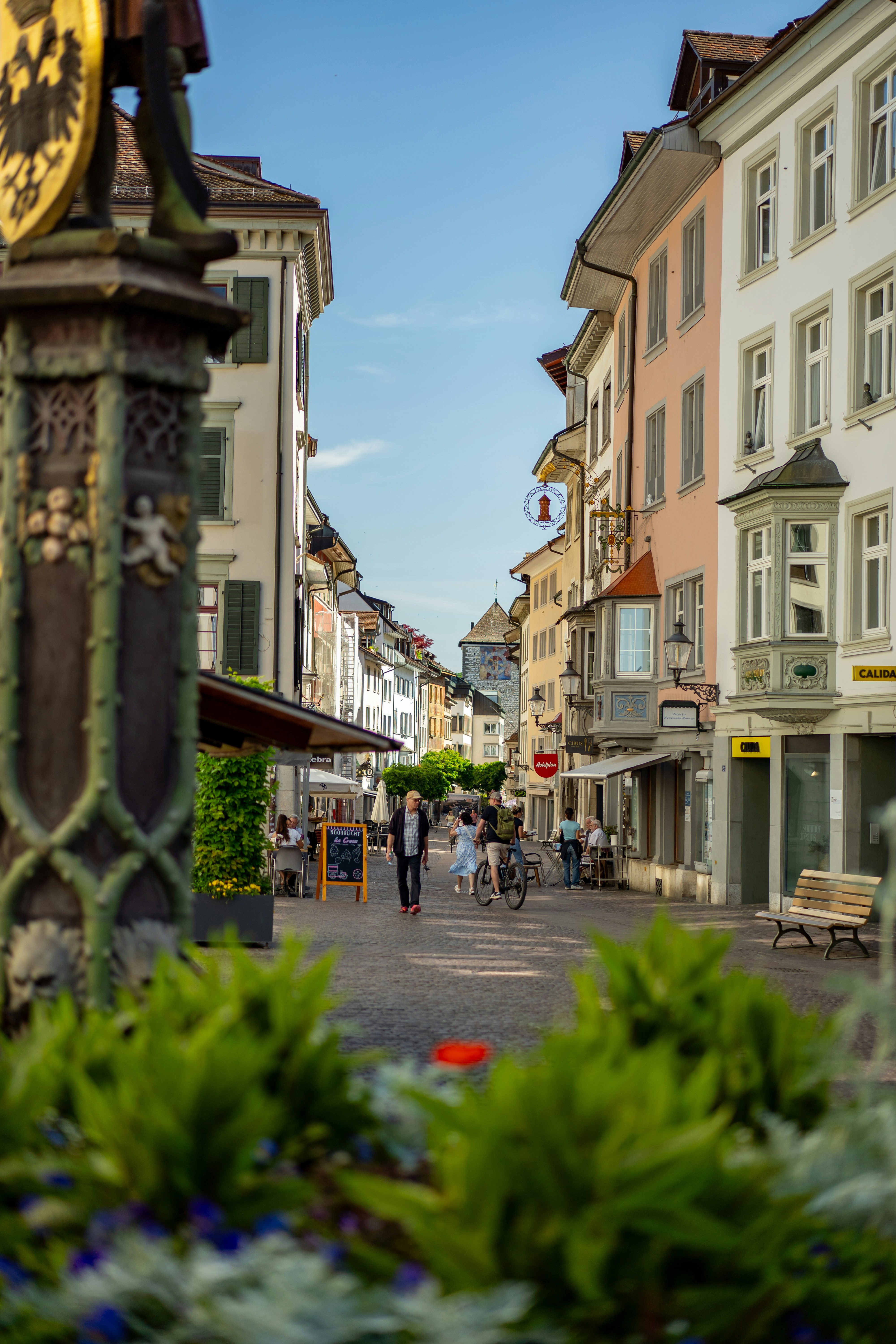Une charmante scène de rue européenne avec des bâtiments historiques et des habitants.