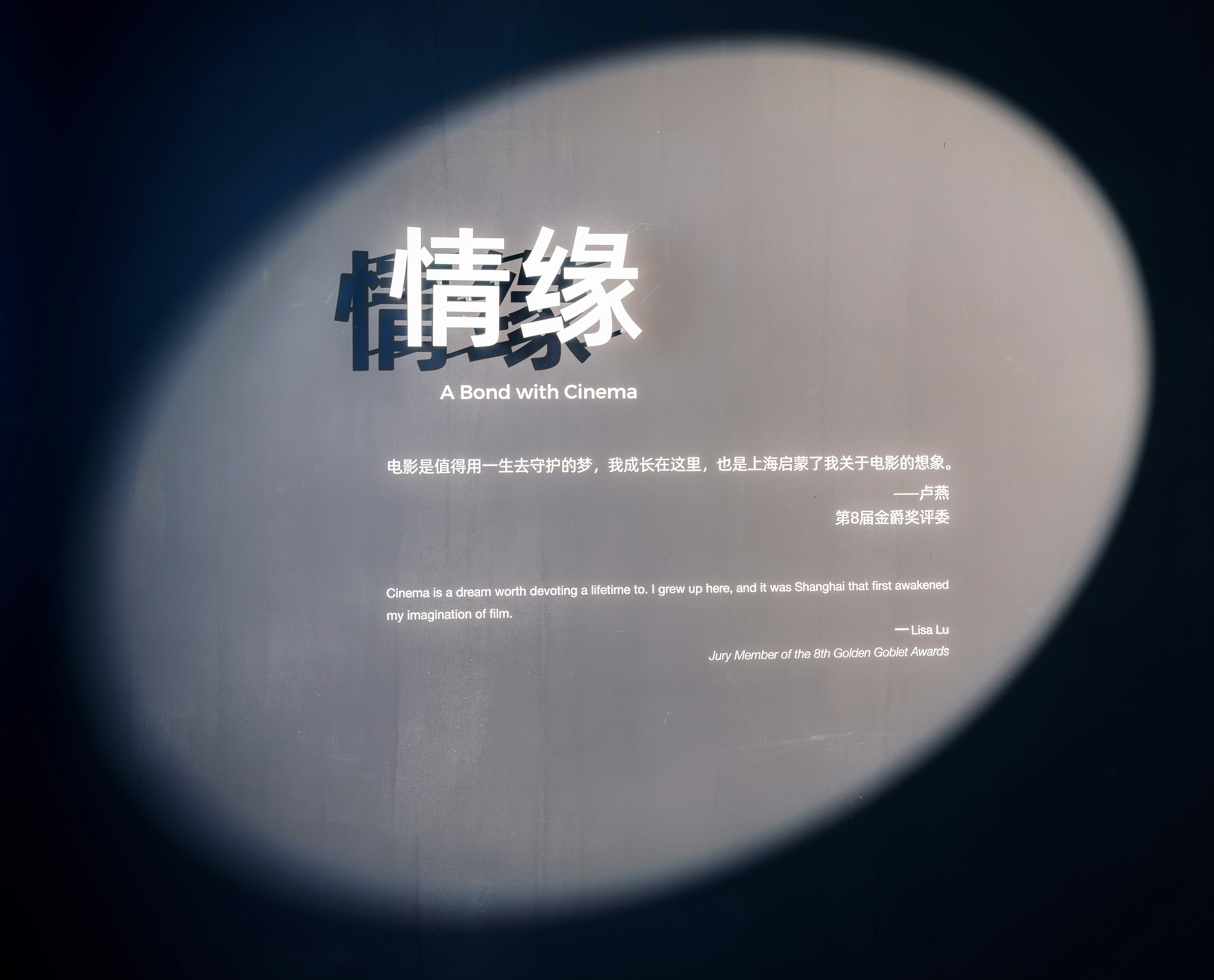 Text "a bond with cinema" projected in a spotlight.