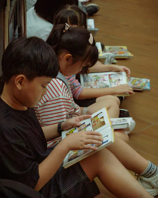 Young children quietly read comic books on the floor