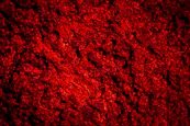 A dark red textured background with rough surface.
