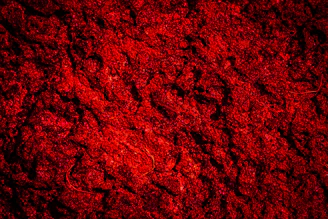 A dark red textured background with rough surface.