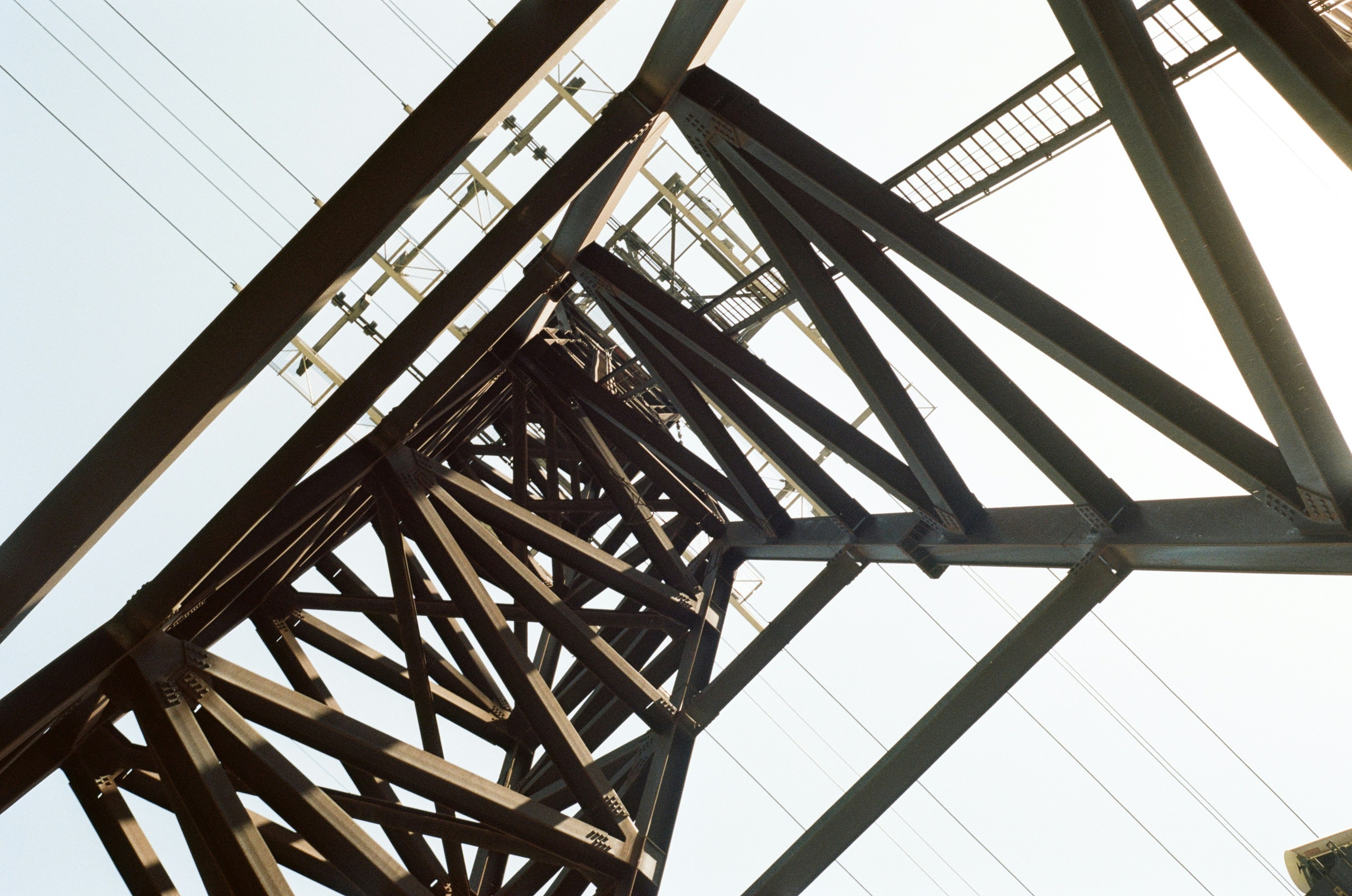 Upward view of a metal power transmission tower.