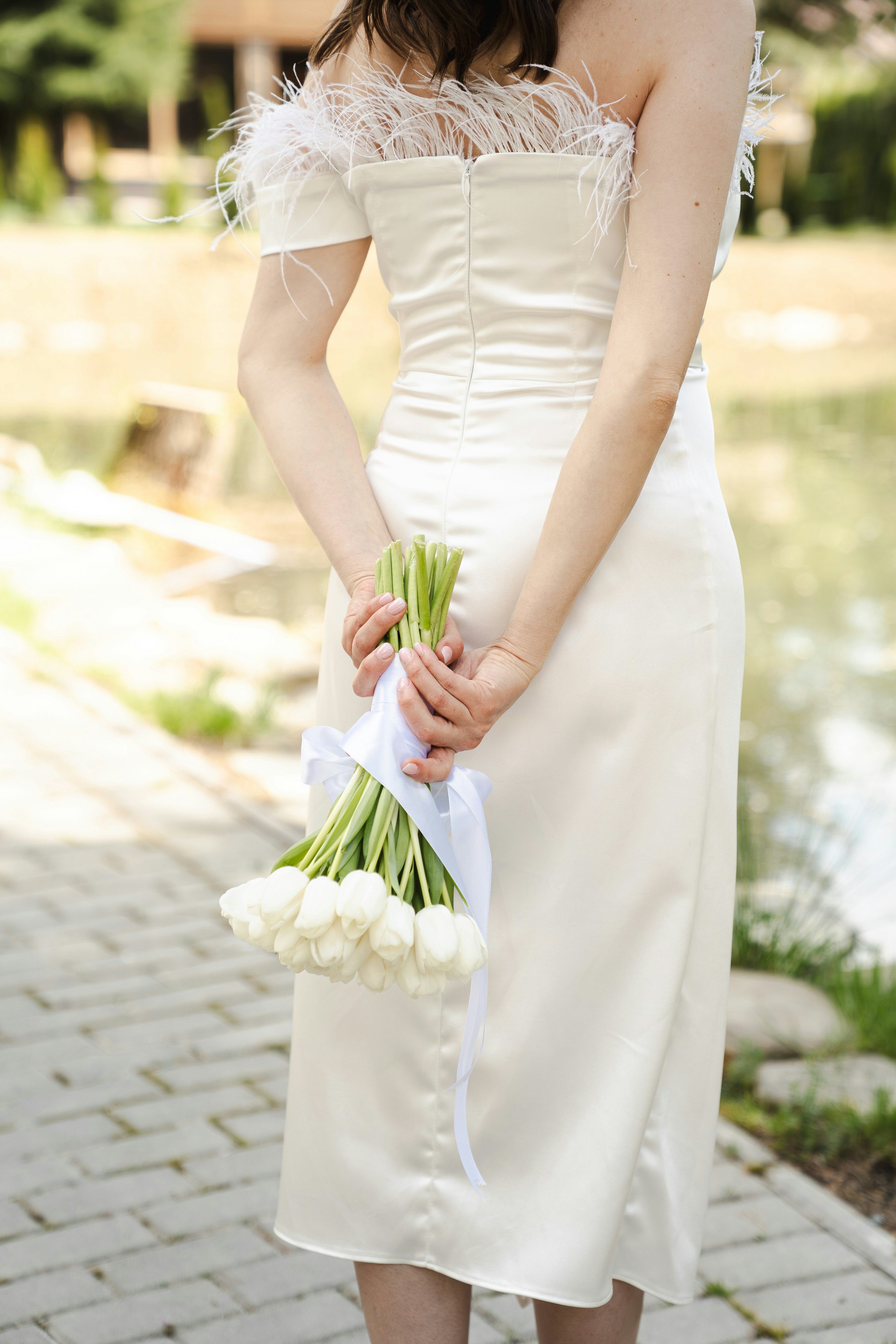 Bride holding preserved wedding flowers during outdoor wedding ceremony