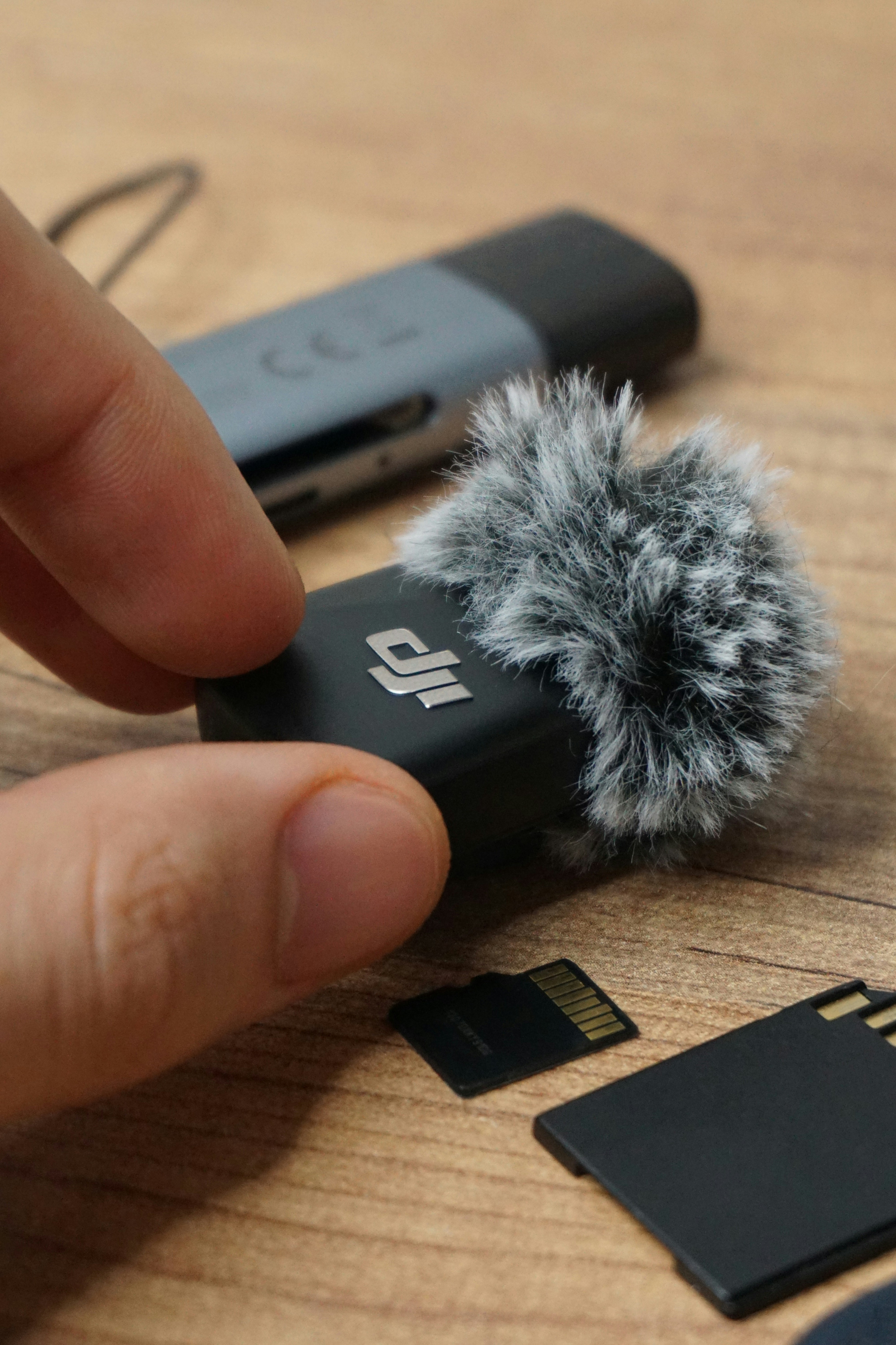 Dji wireless microphone with furry wind muff and memory cards.