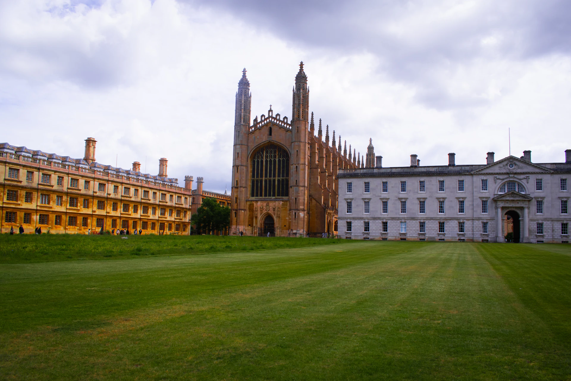 Historic college chapel and buildings with a large green lawn.