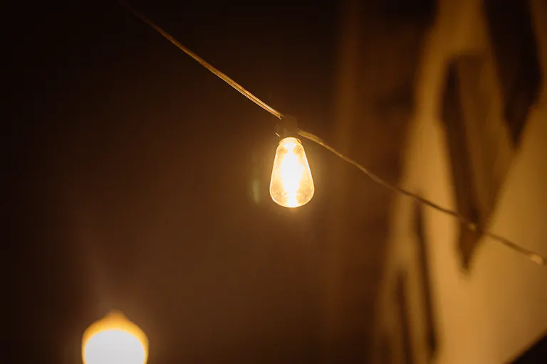 A warm light bulb glowing against a dark background