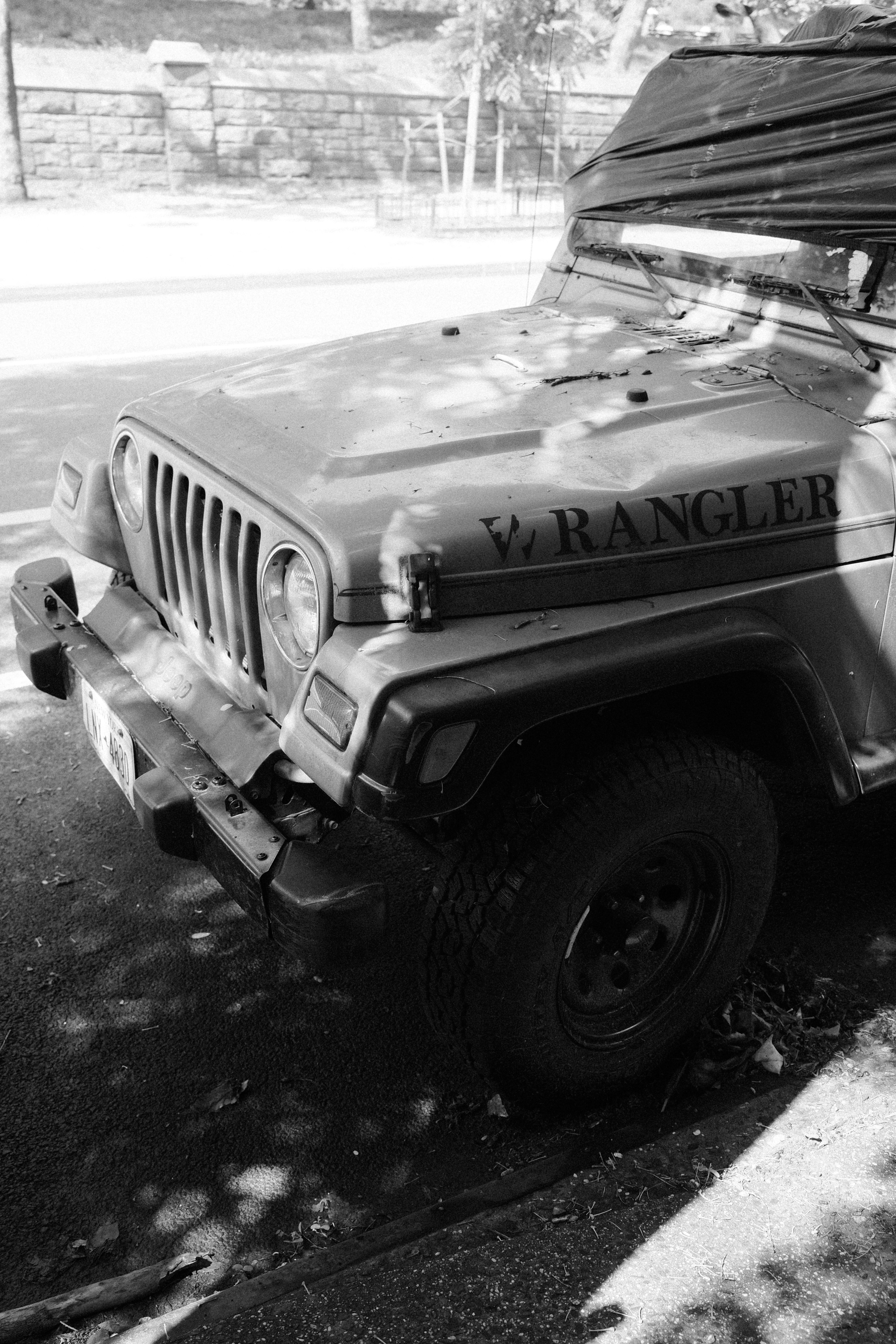 A jeep wrangler parked with shadows in black and white.