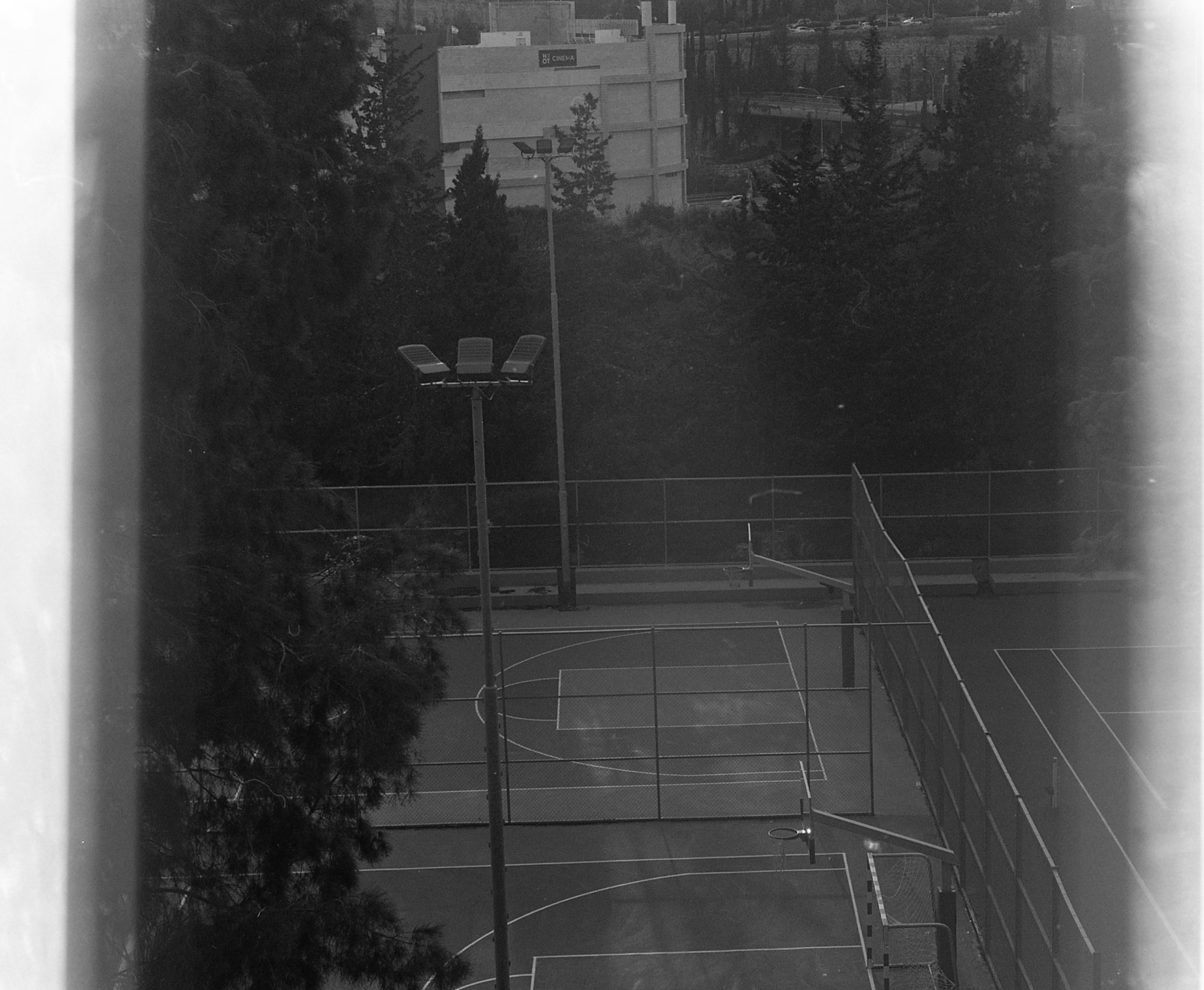 Overhead view of an outdoor basketball and tennis court.