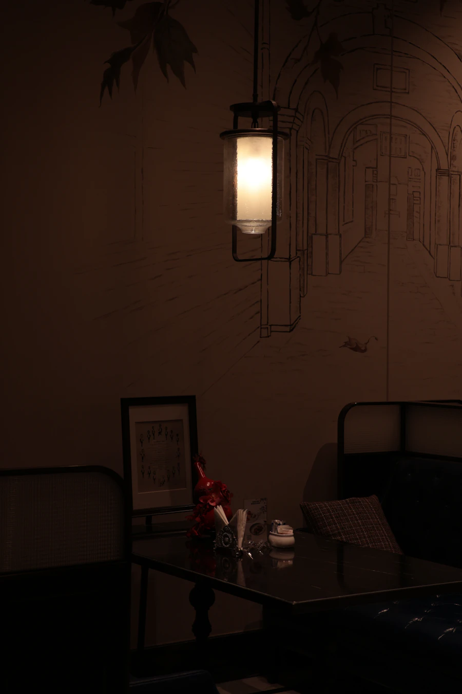 A lantern hanging over a table in a dark dining room