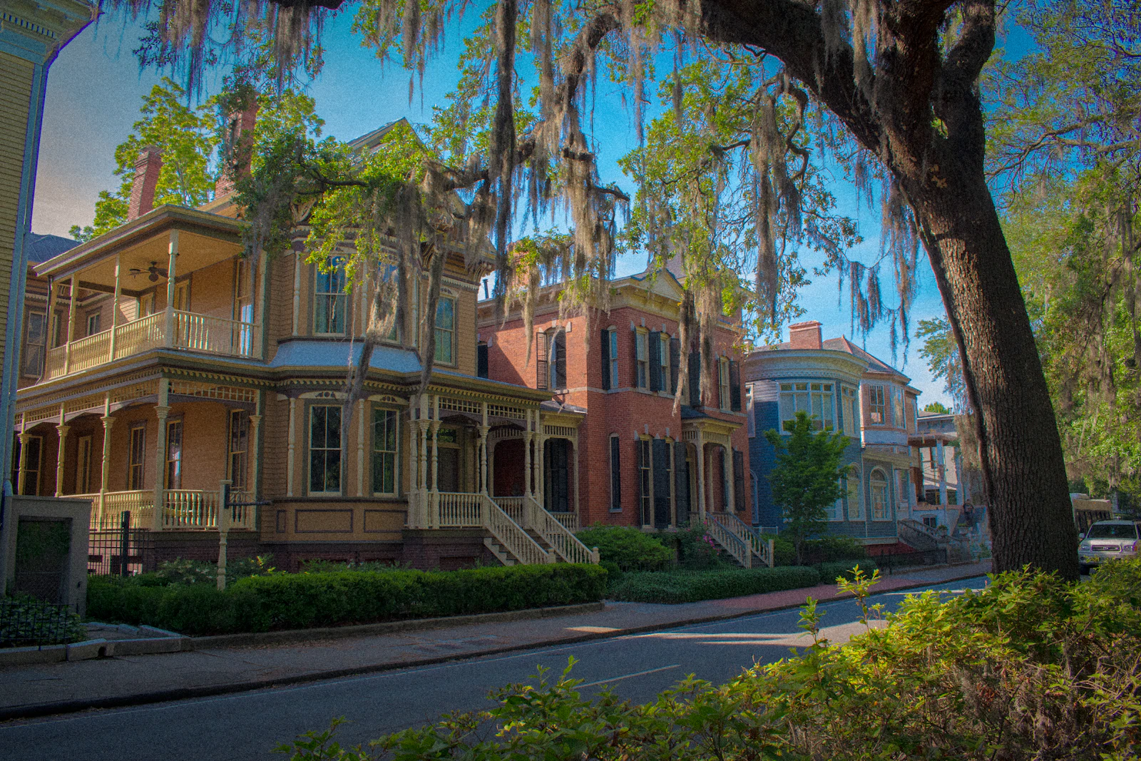 Historic downtown street lined with older homes near a riverfront