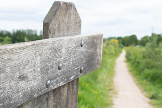 Old wooden fence post beside a winding dirt path.