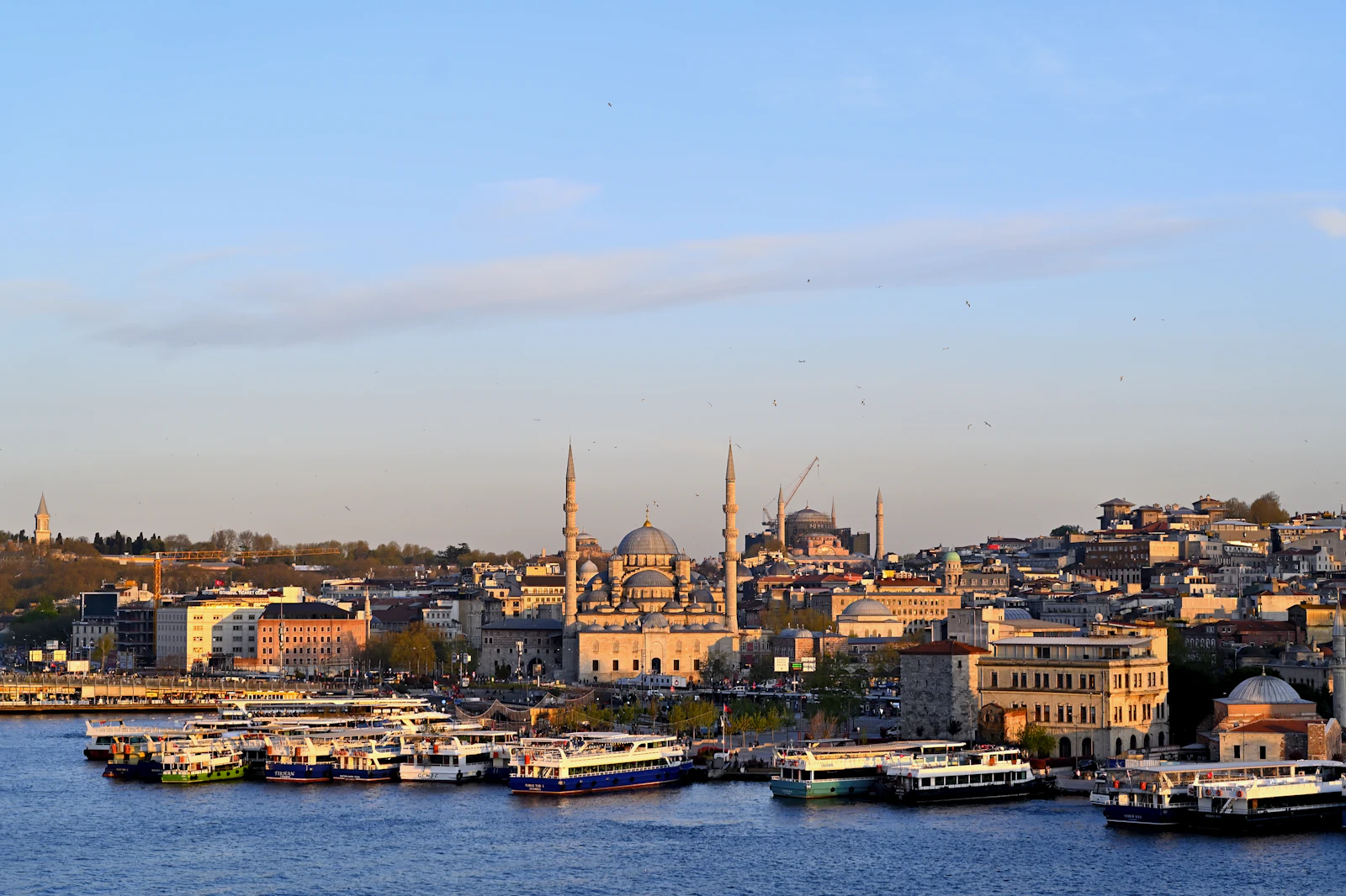 The New Mosque and Hagia Sophia above the Golden Horn ferry piers at sunset