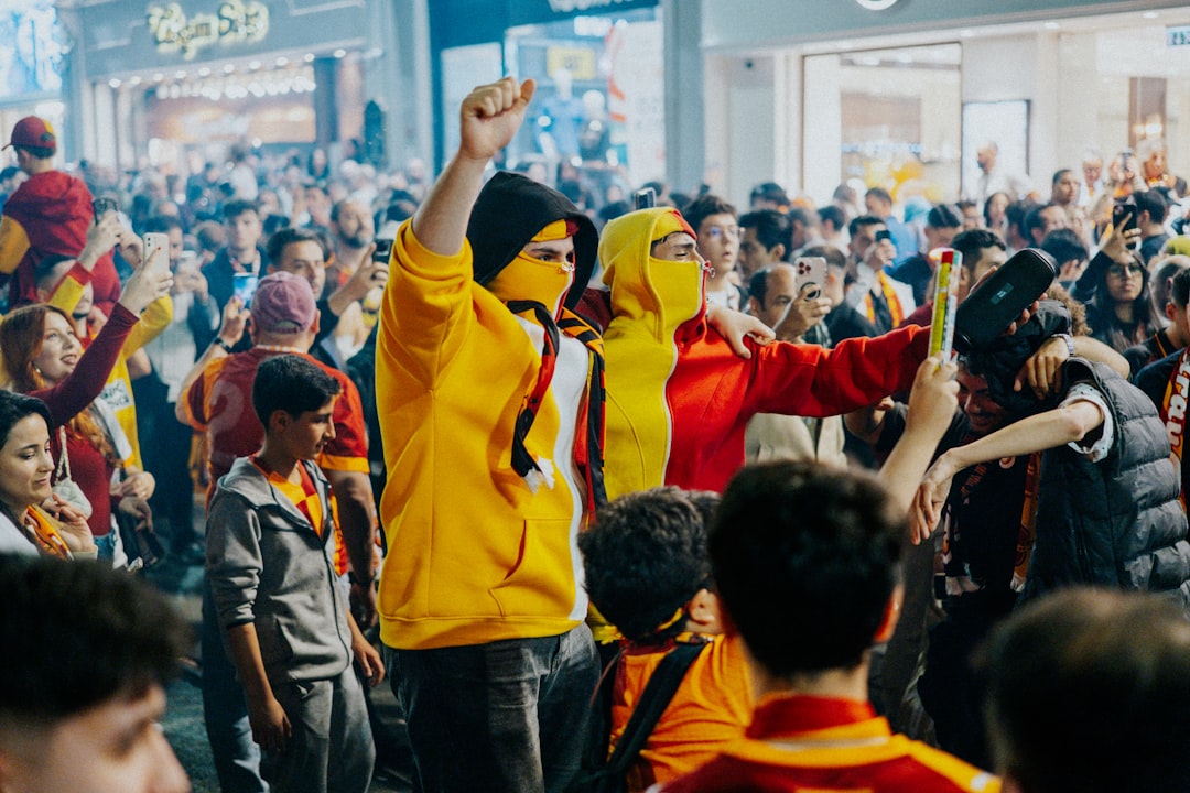Enthusiastic crowd celebrating in yellow and red attire.