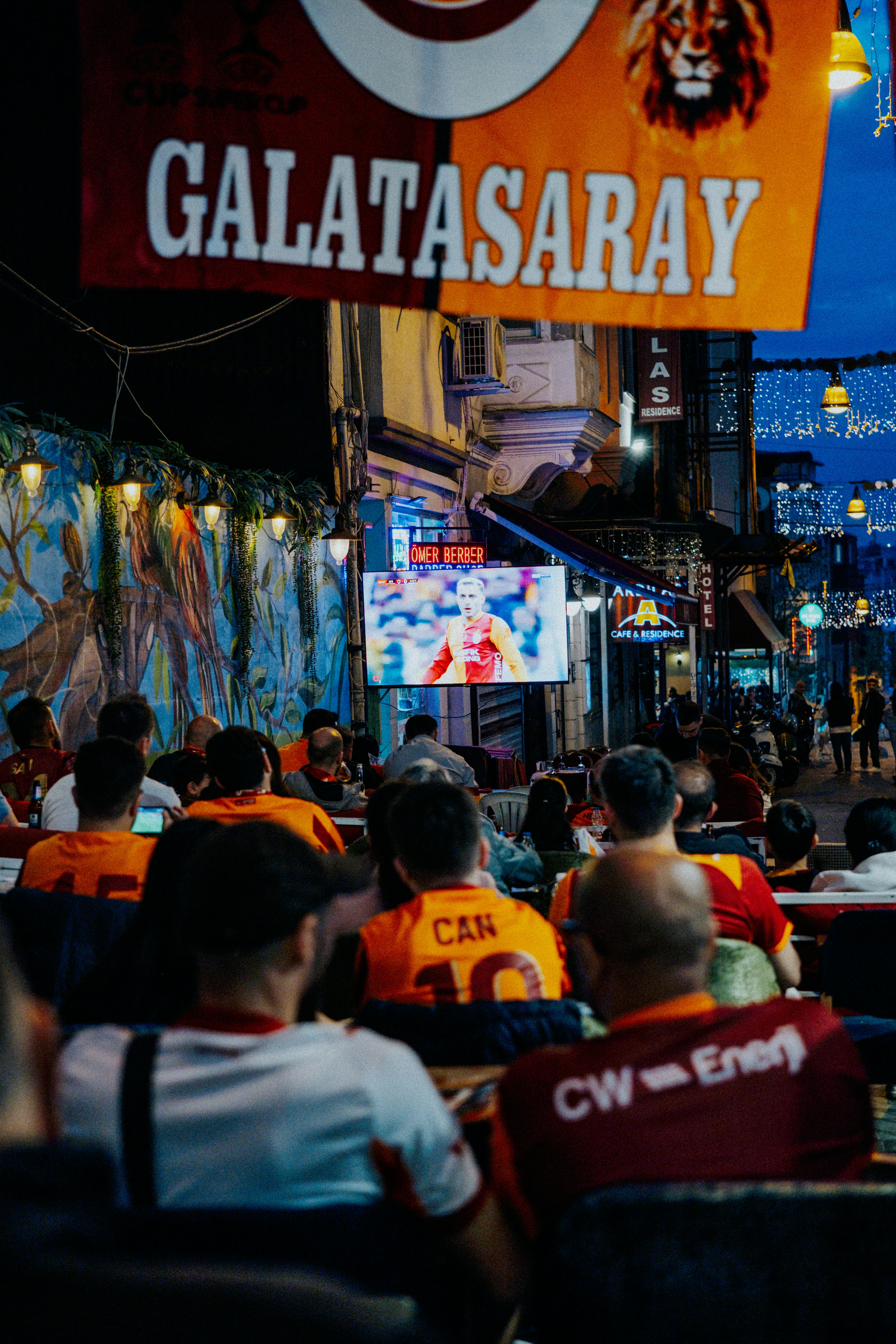 Penggemar Galatasaray menonton pertandingan sepak bola di layar luar ruangan.
