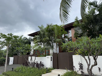 Contemporary home with green foliage and a brown fence.