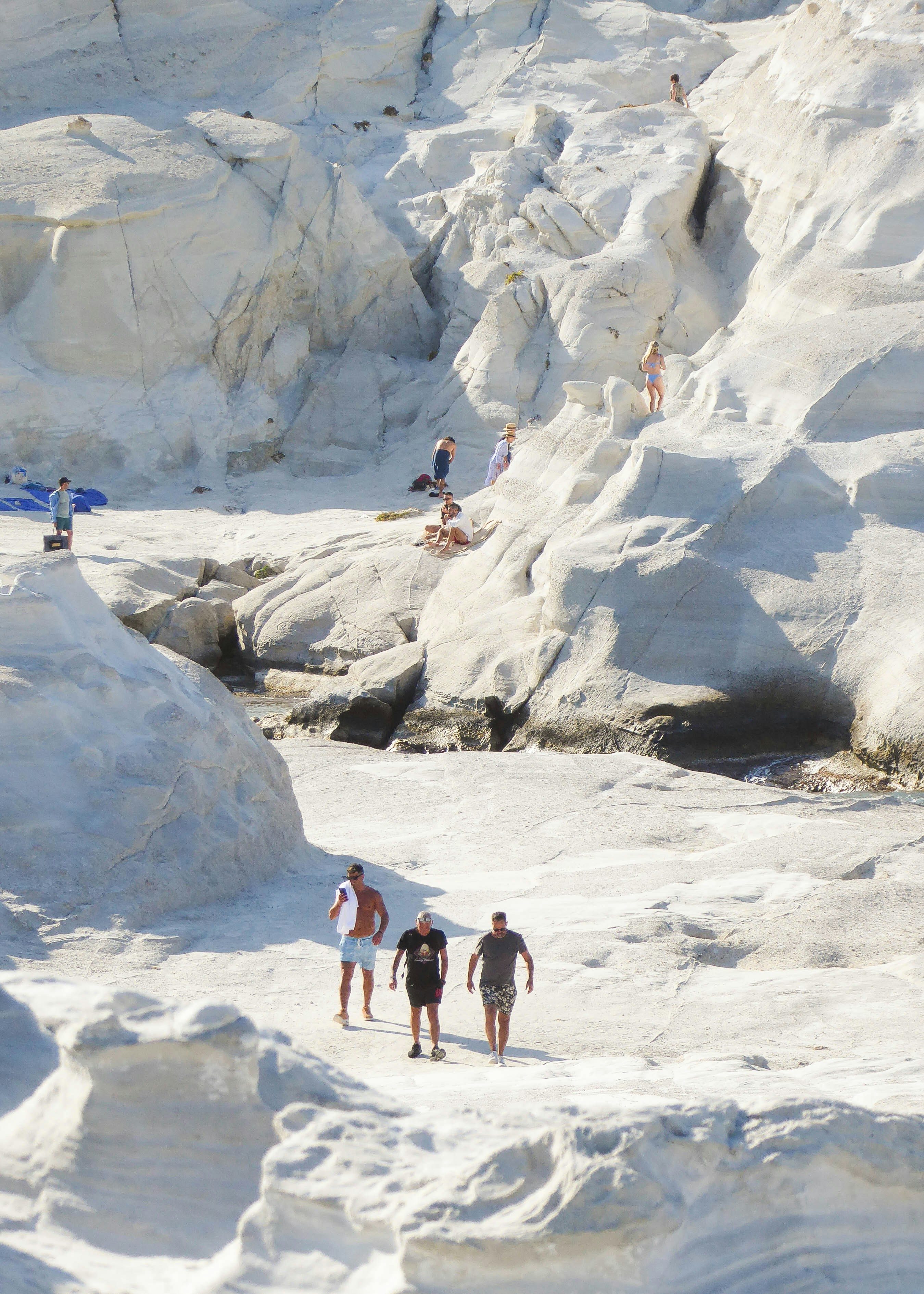 Des gens explorant des formations rocheuses blanches sculptées uniques.