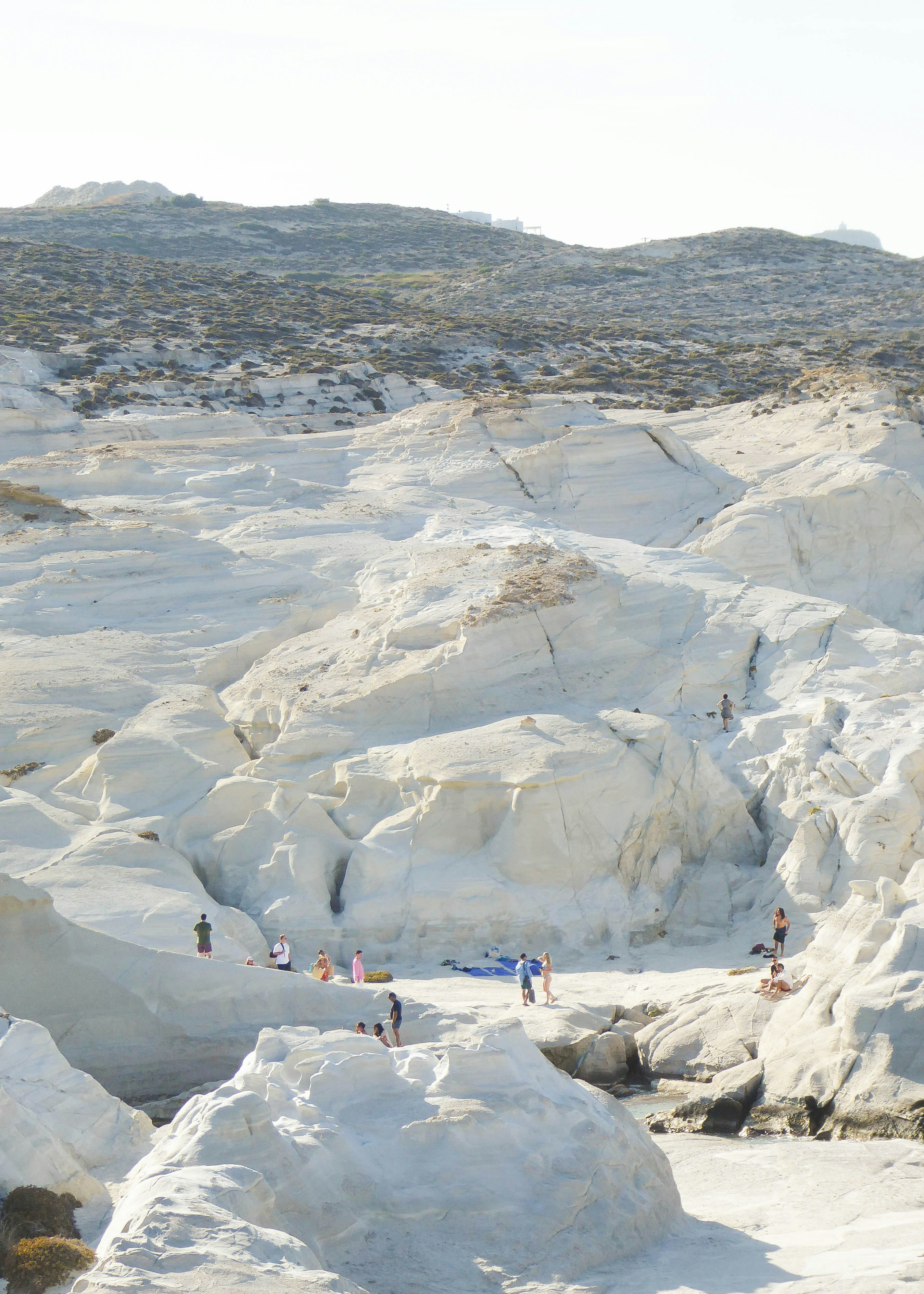 Paysage volcanique blanc avec des gens profitant de la plage.
